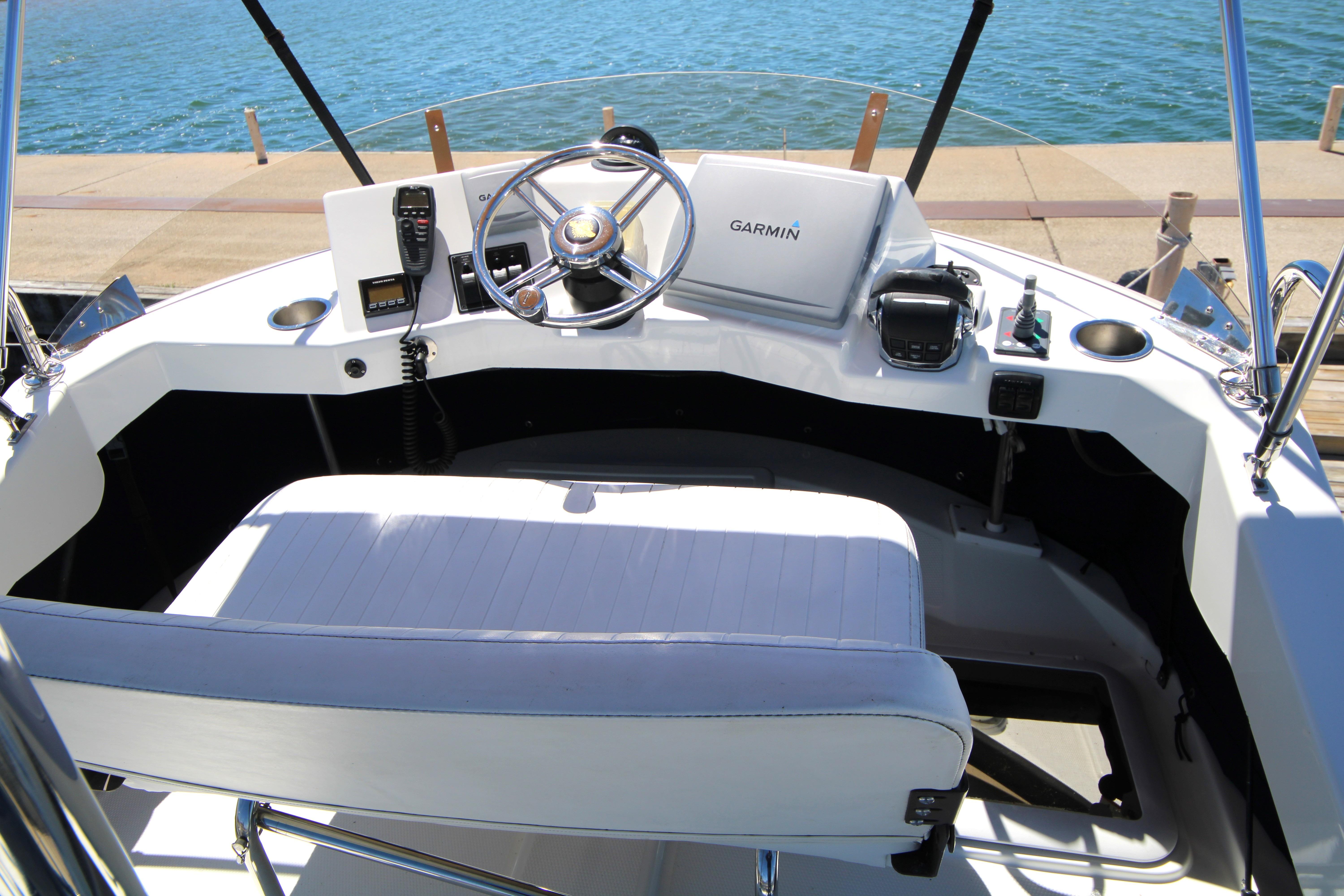 Cockpit of 2013 Ranger Tugs R-31 CB with Garmin navigation system, docked by the water.