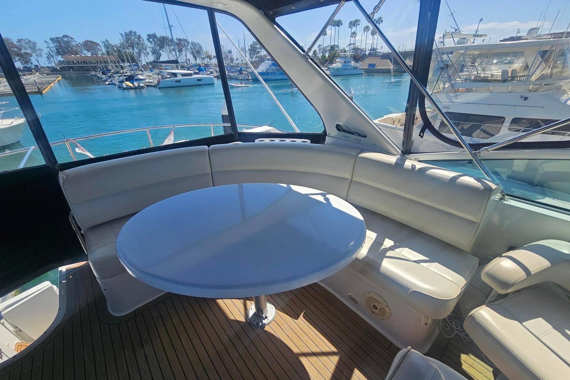 Luxurious seating area on 2002 Carver 450 Voyager Pilothouse yacht, overlooking marina.