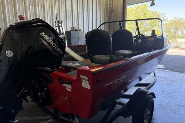 2026 Tracker Pro Guide V-16 WT boat with Mercury engine in a garage setting.