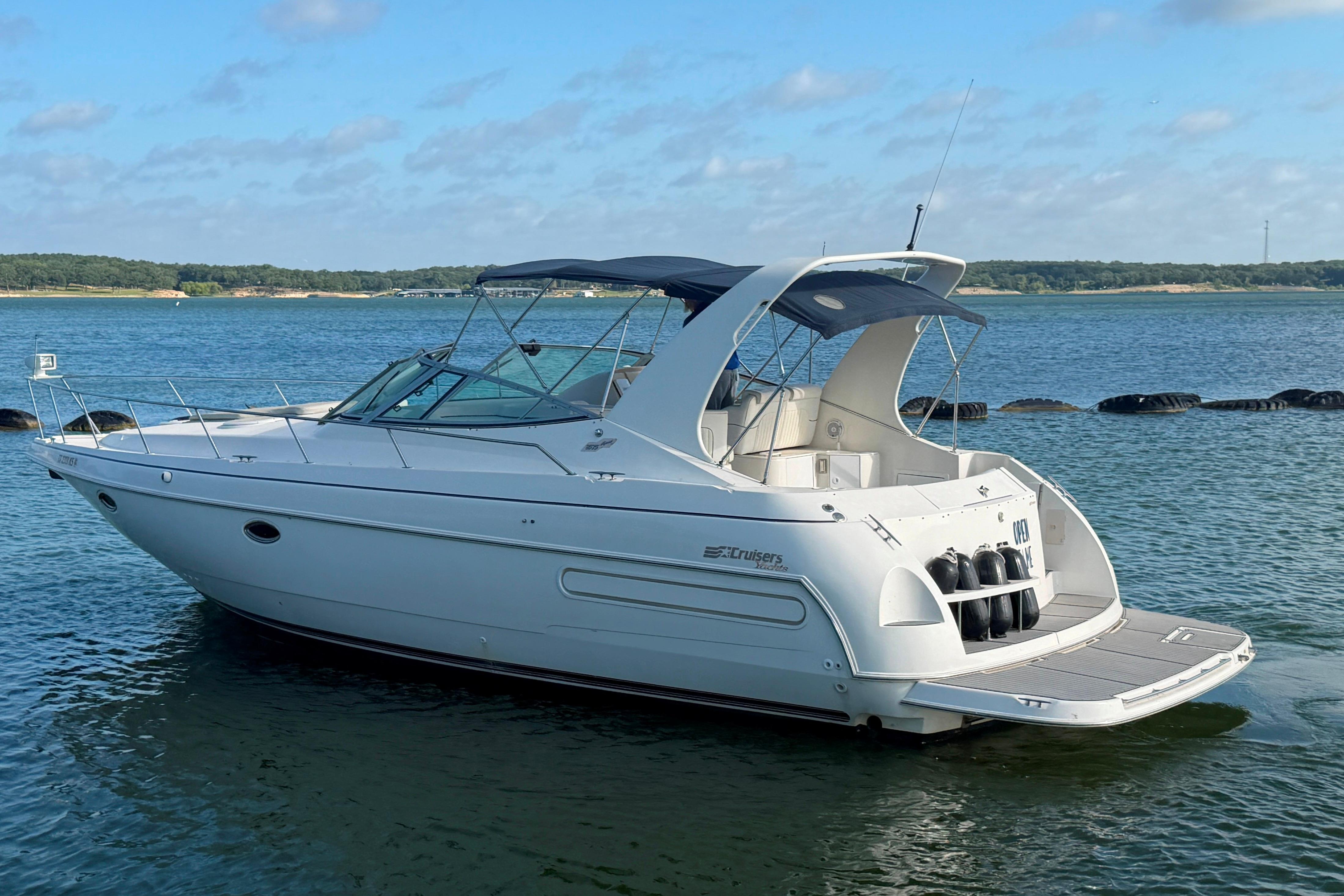 1997 Cruisers 3575 yacht on calm water, featuring sleek design and spacious deck.