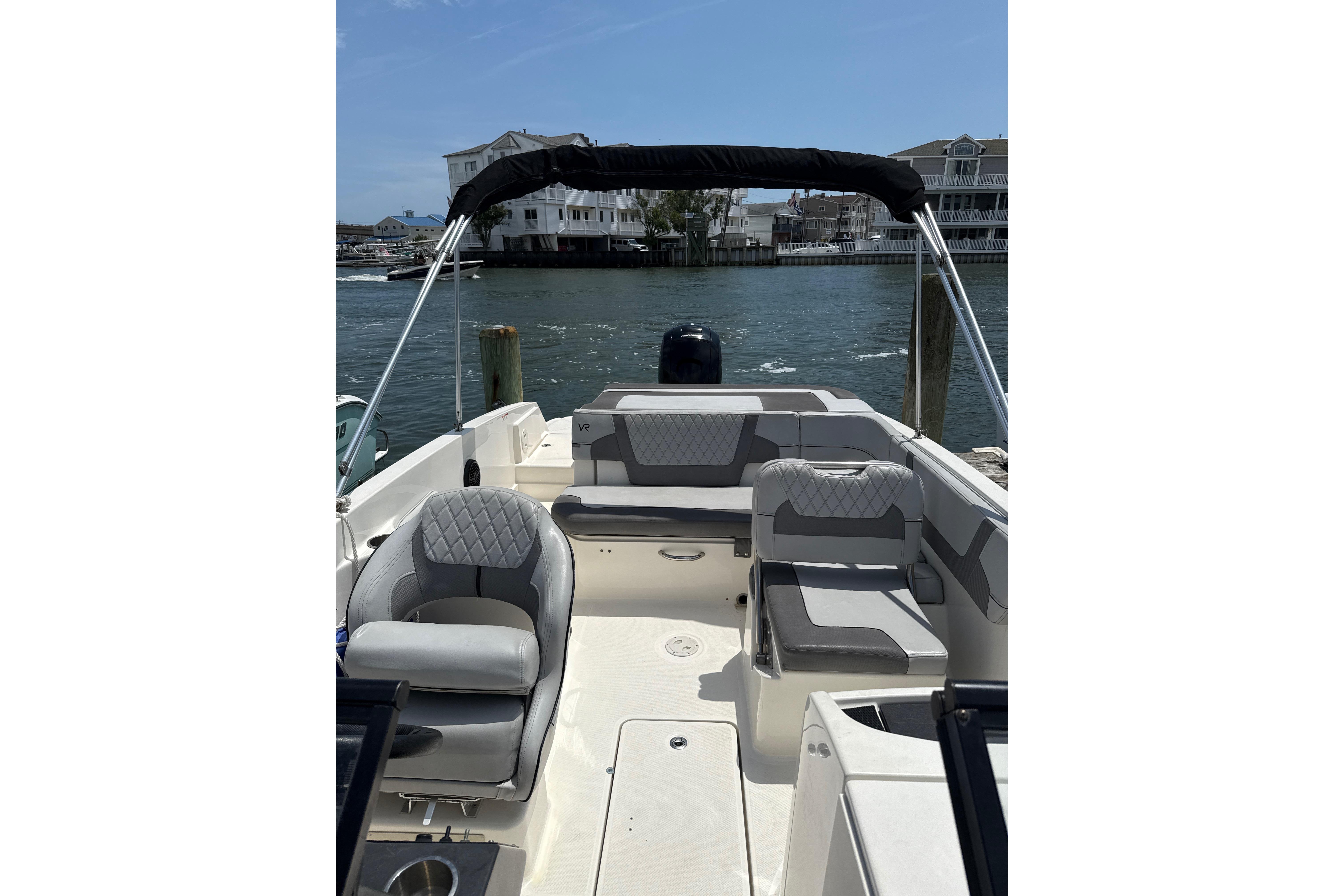 2023 Bayliner VR6 Bowrider OB with spacious seating, docked by waterfront homes.