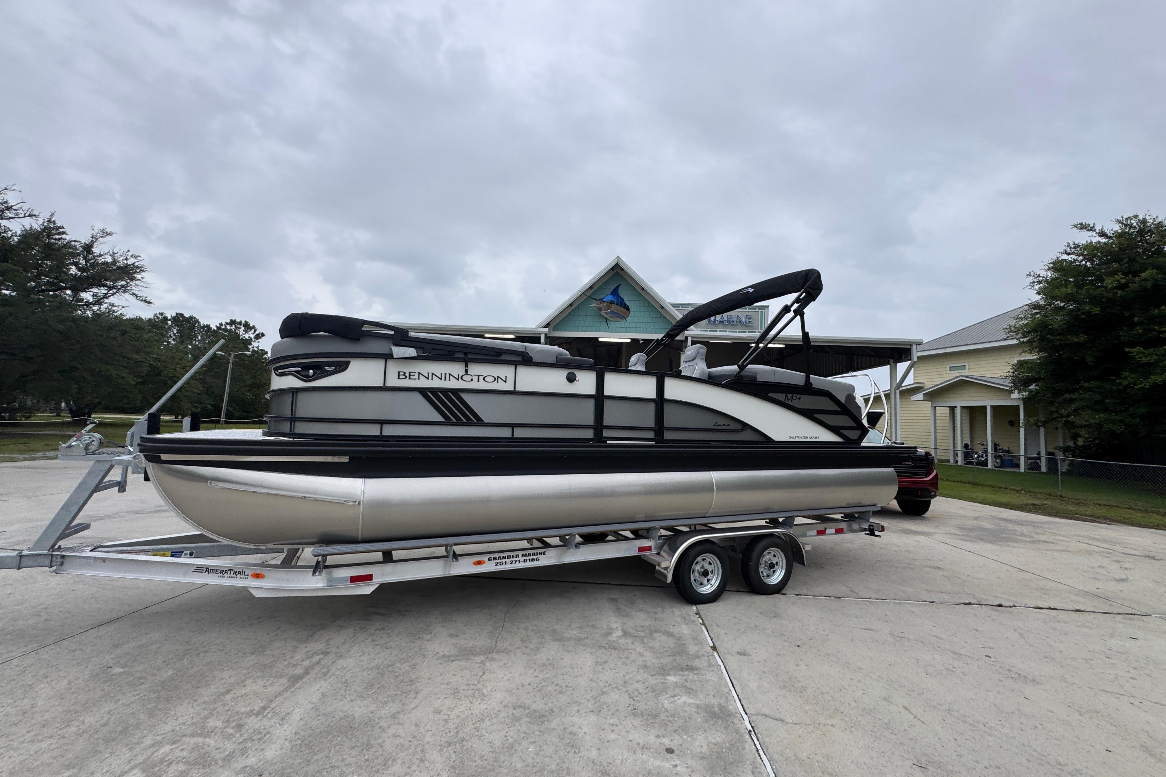 2027 Bennington 24 MFB pontoon boat on trailer, parked outdoors.