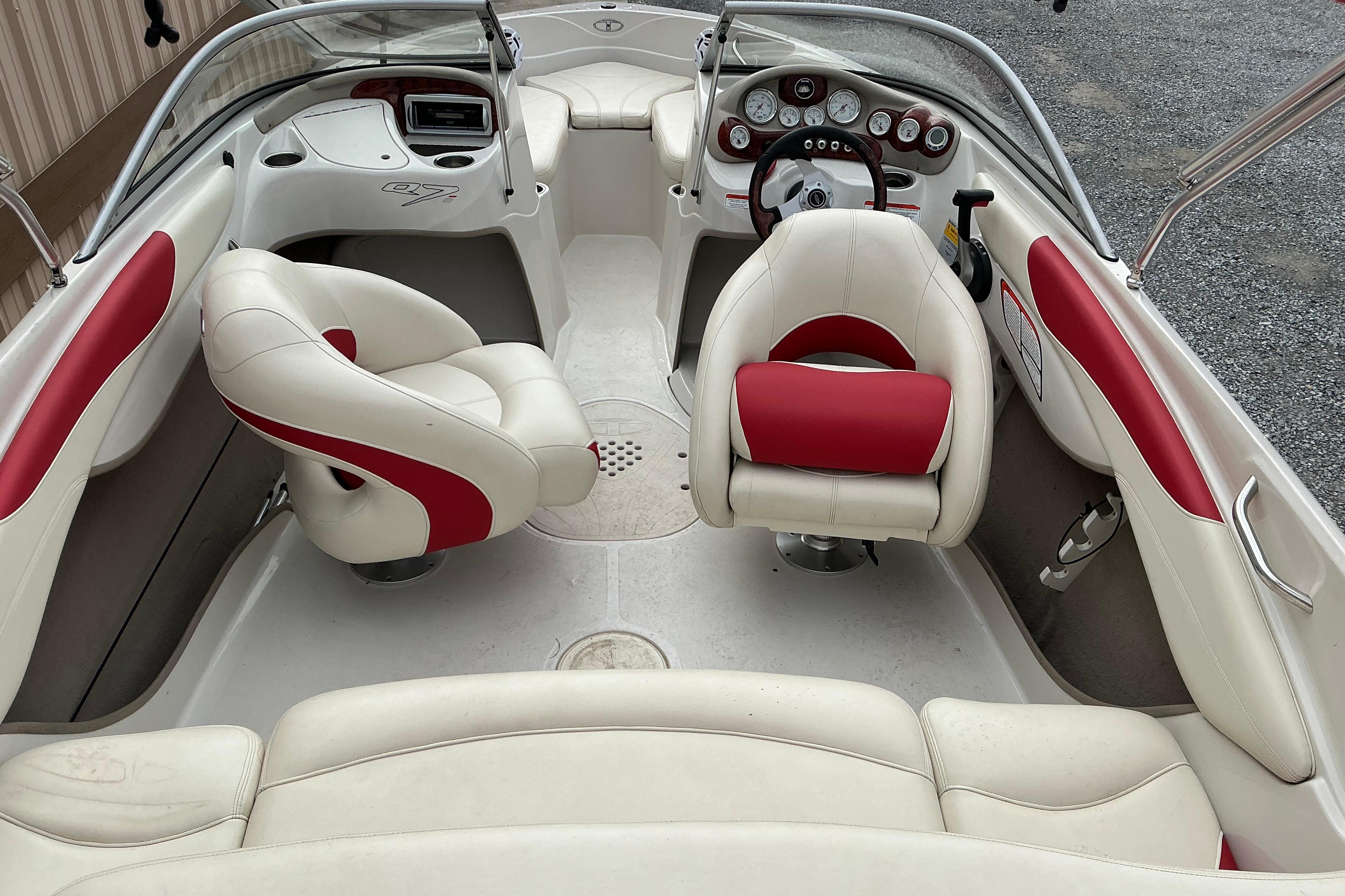 2014 Tahoe Q7i boat interior with white and red seating, steering wheel, and dashboard.