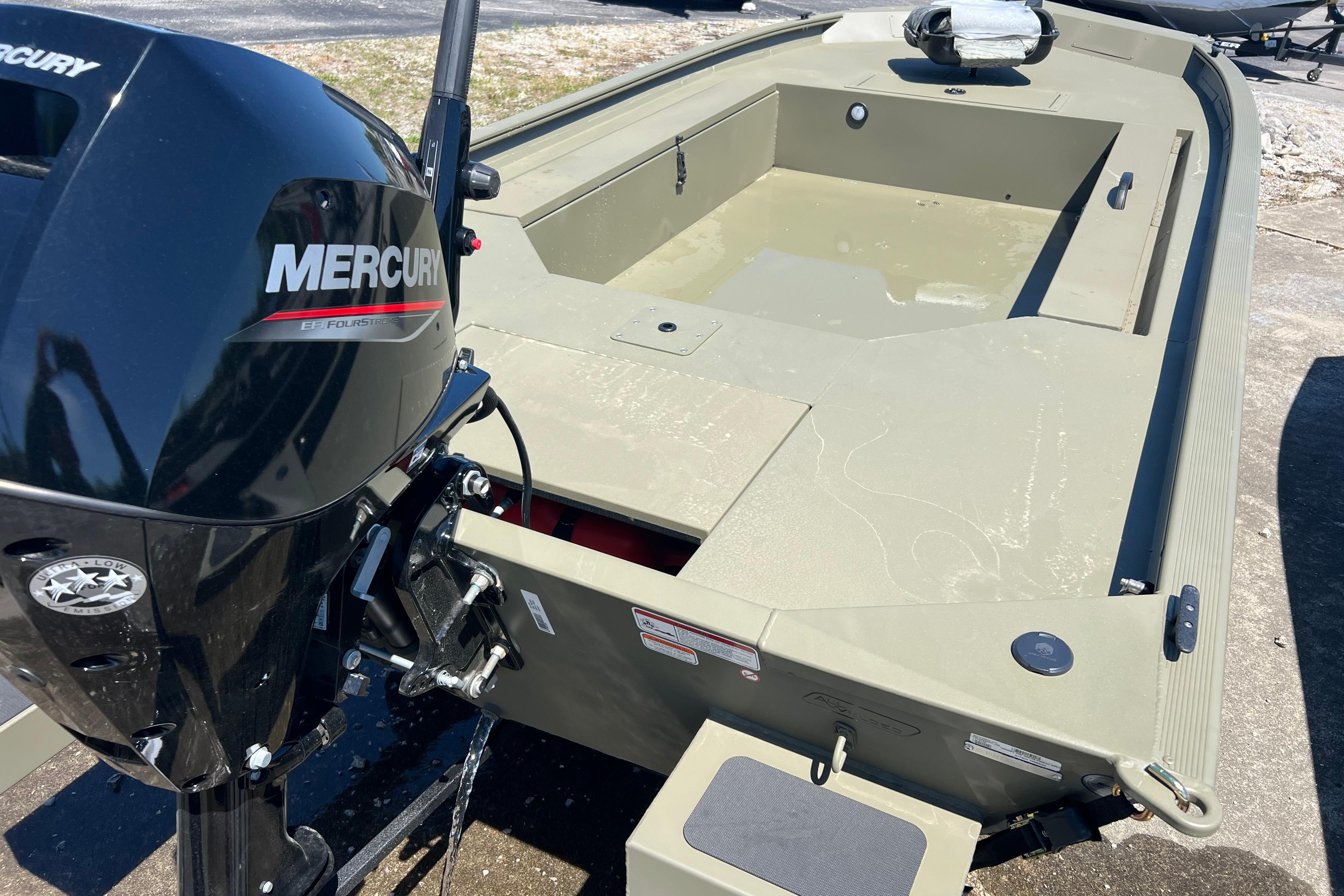2026 Tracker Grizzly 1654 T Sportsman boat with Mercury outboard motor, parked on concrete.