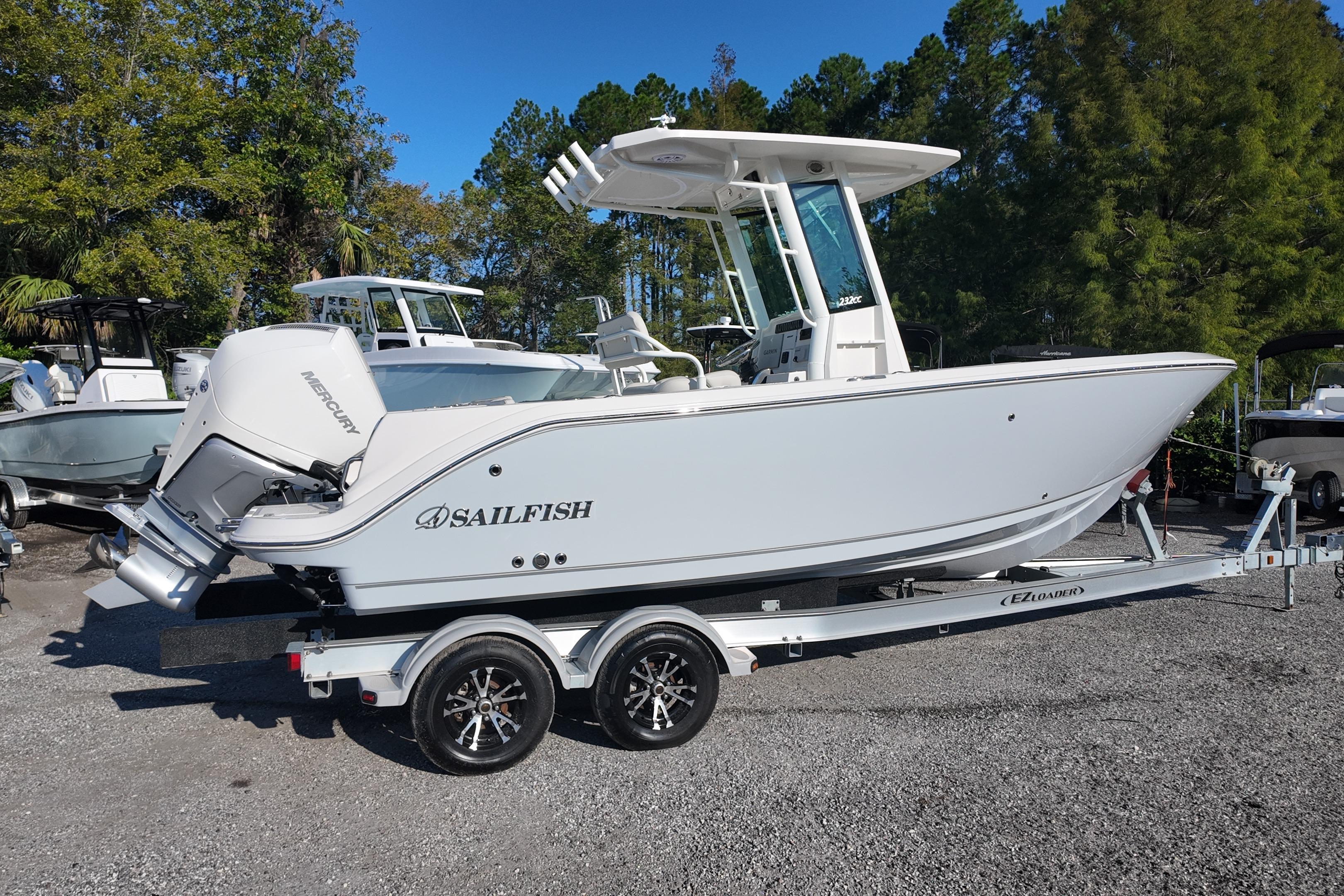 2026 Sailfish 232 CC boat on trailer, parked outdoors with trees in background.