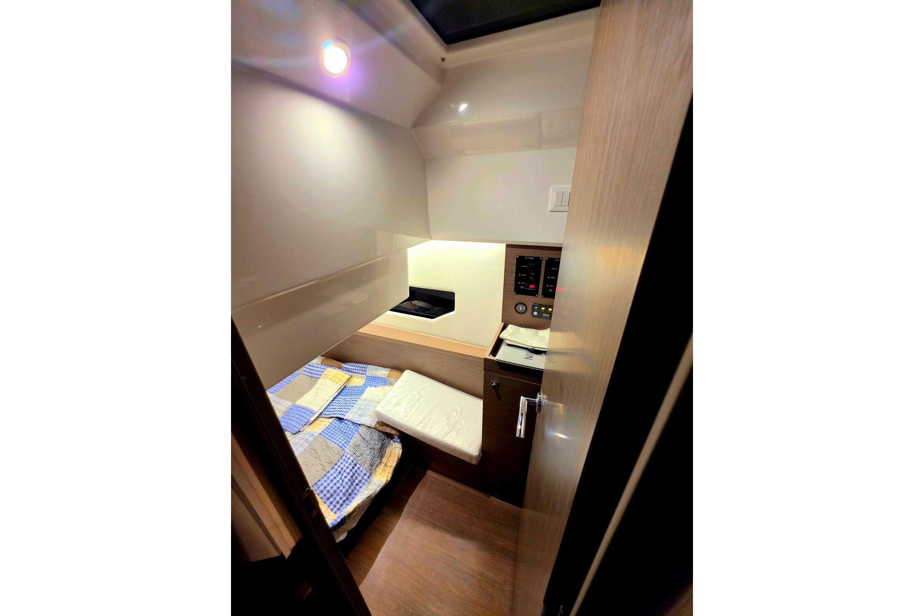 Interior cabin of 2026 Jeanneau NC 895 Series 2, featuring cozy bed and control panel.