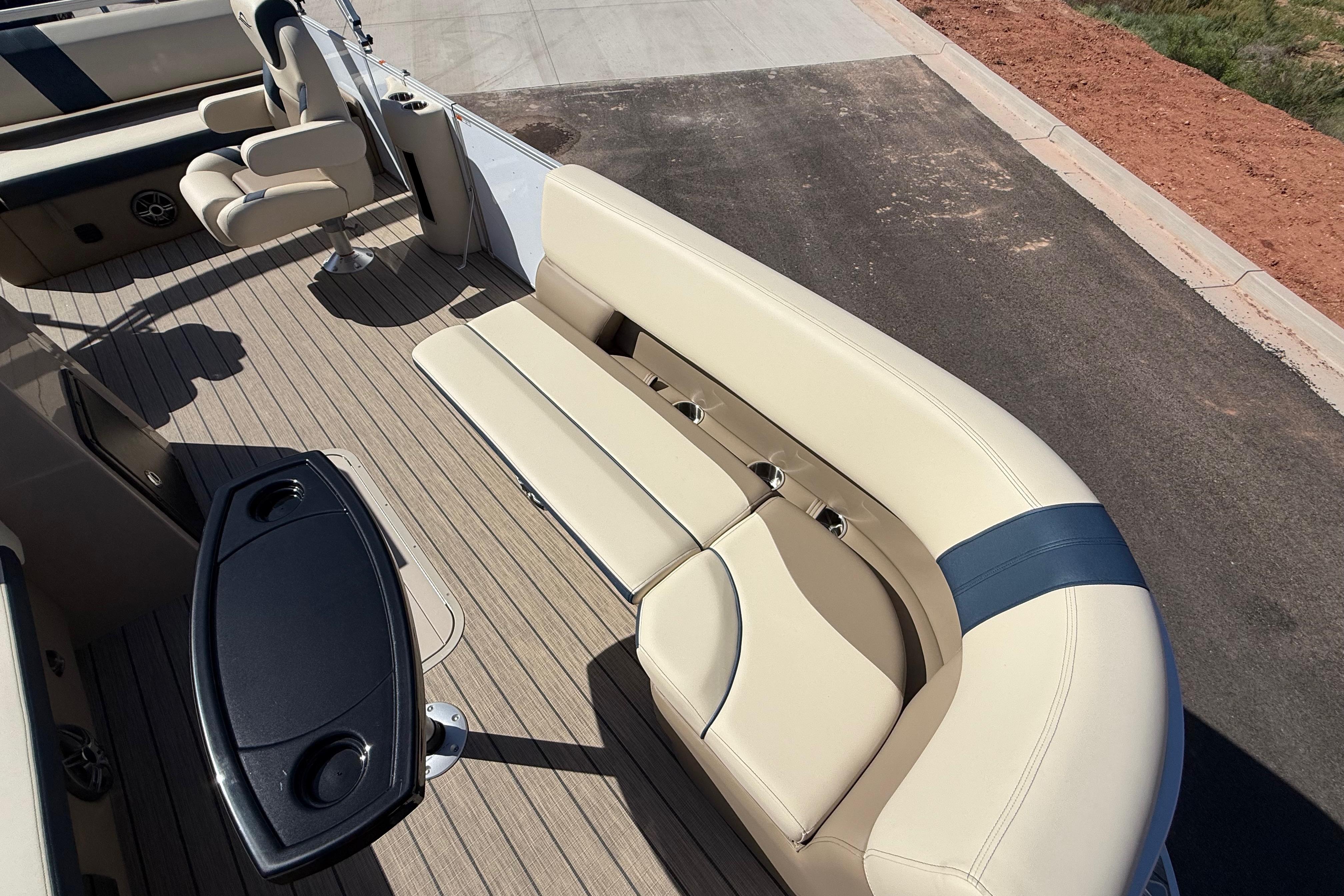 2026 SunCatcher Select 322SL boat interior with beige seating and wood-style flooring.