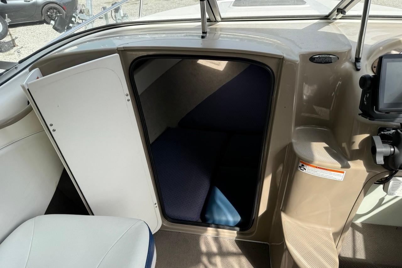 2005 Bayliner 210 Discovery cabin interior with open door and seating area.
