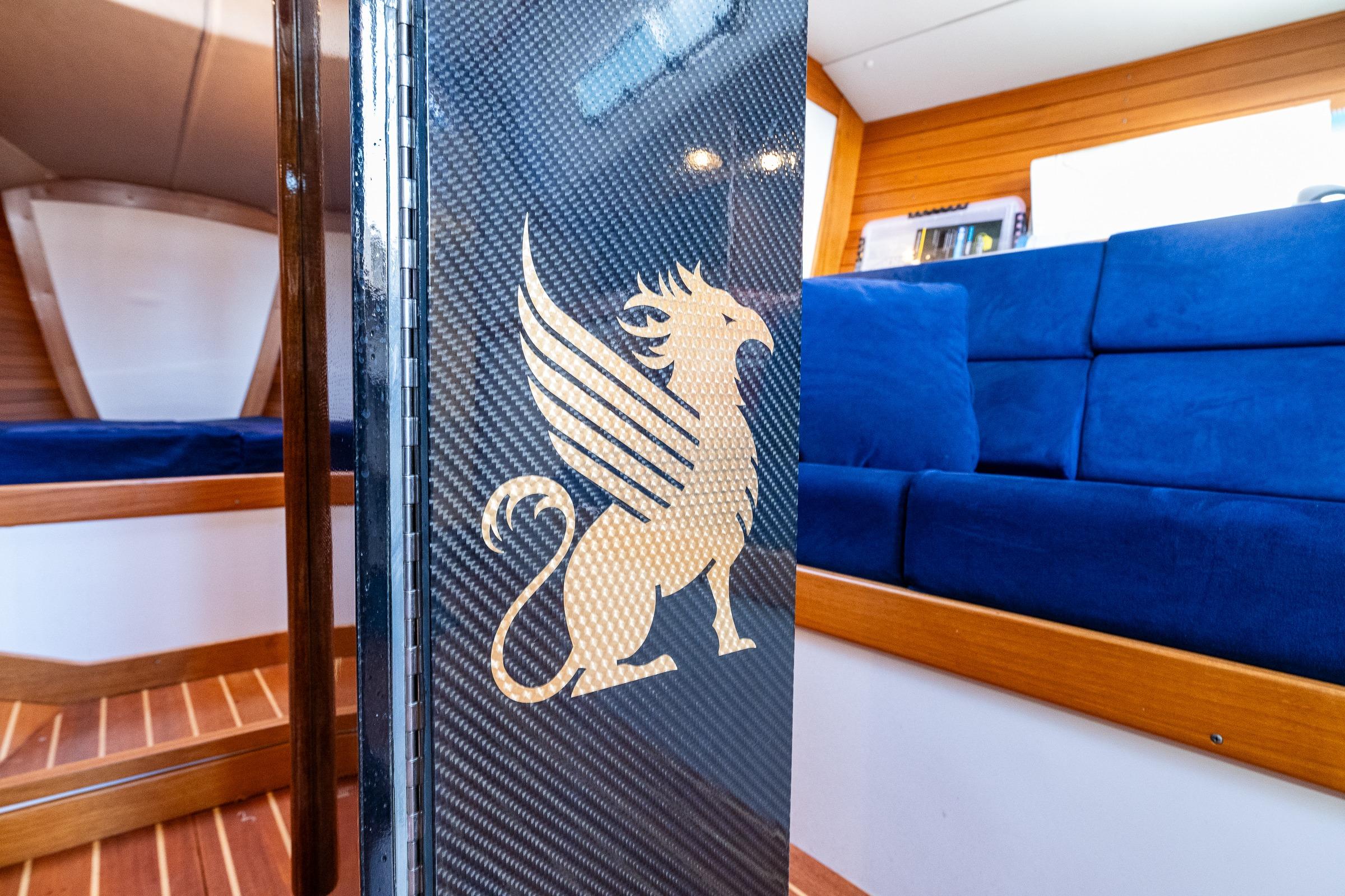 Interior of 2007 J Boats J/124 yacht with griffin emblem and blue seating.
