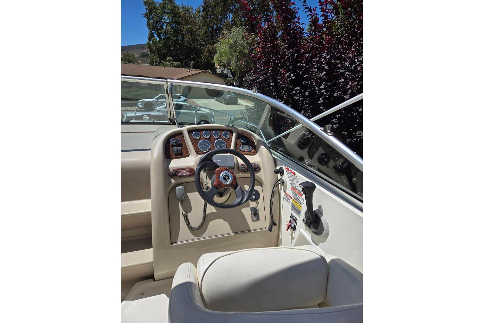2004 Sea Ray Sundancer 260 boat cockpit with steering wheel and control panel.
