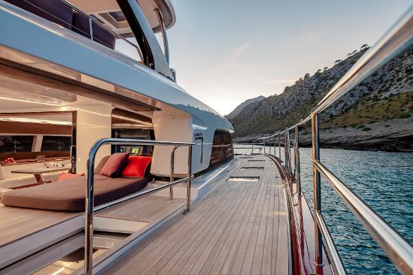 Luxurious 2025 Lagoon SIXTY 7 yacht deck with scenic coastal view at sunset.