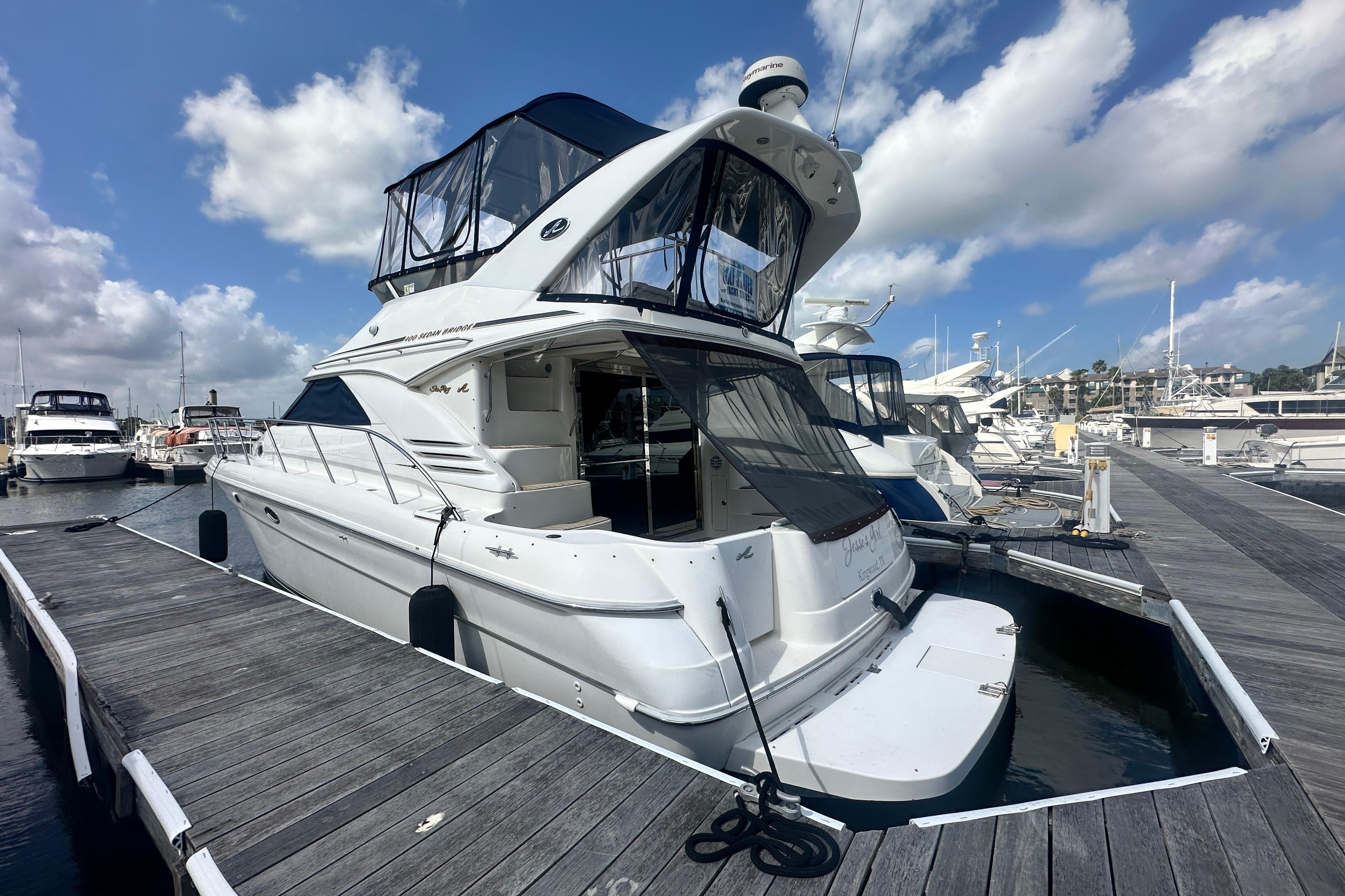 1997 Sea Ray 400 Sedan Bridge yacht docked at marina under blue sky.