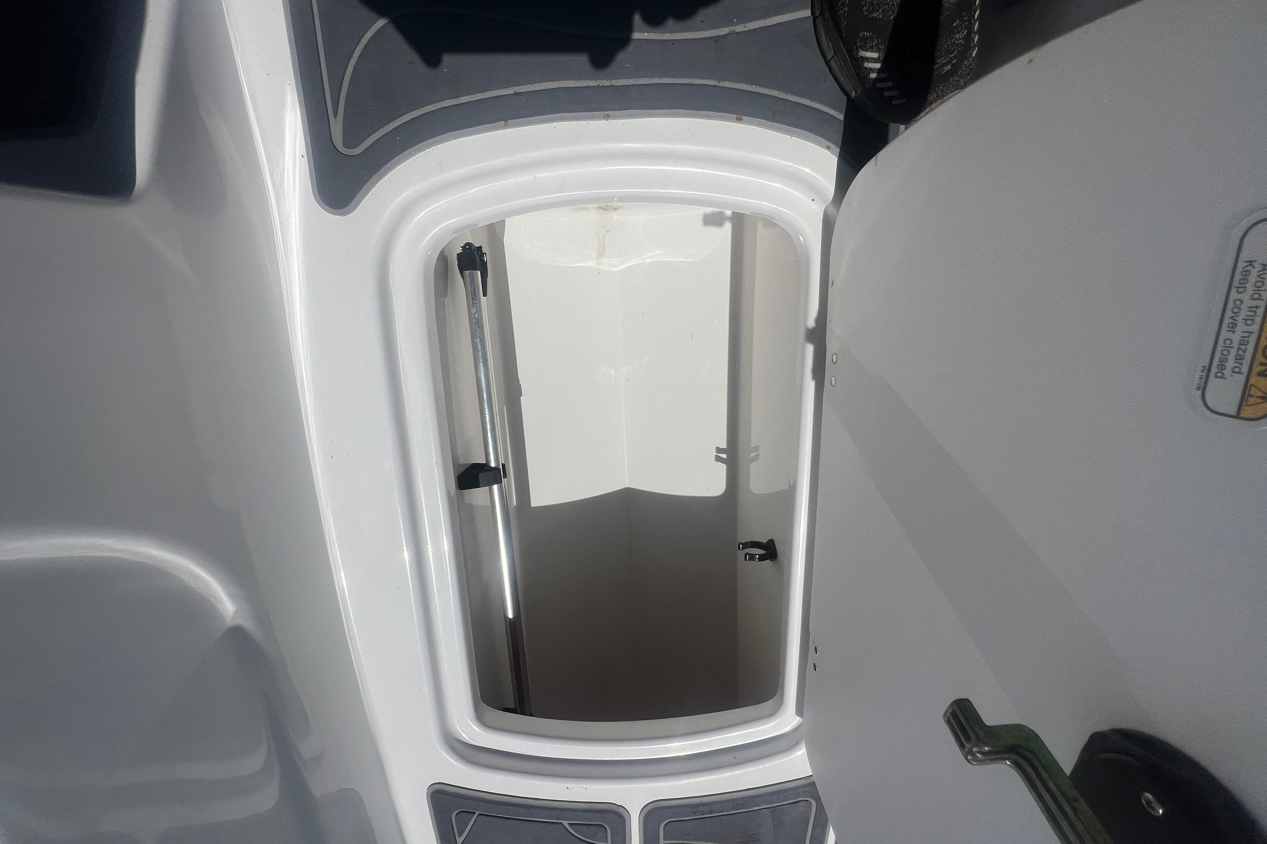 Open storage compartment on 2023 Tahoe T16 boat, showcasing interior space.