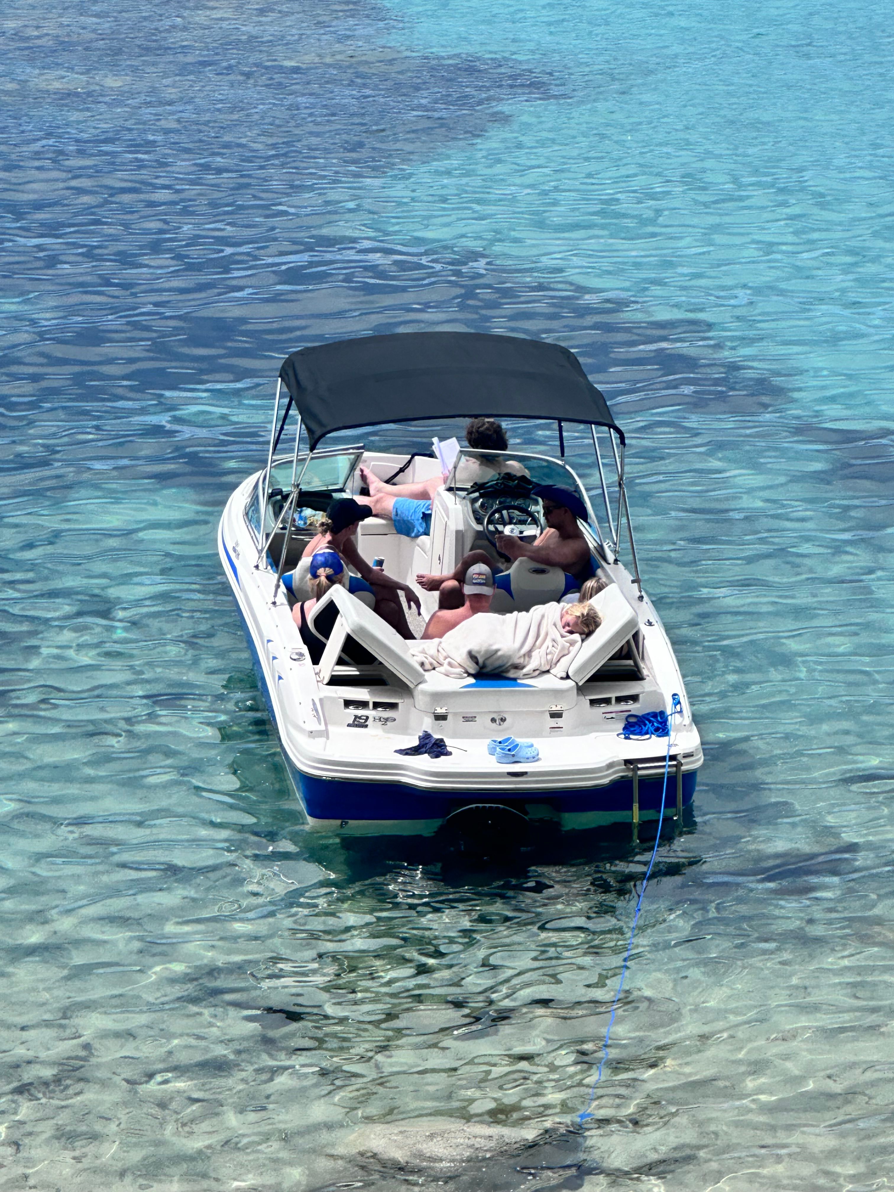 2017 Chaparral 19 H2O Sport on clear water with several people on board.
