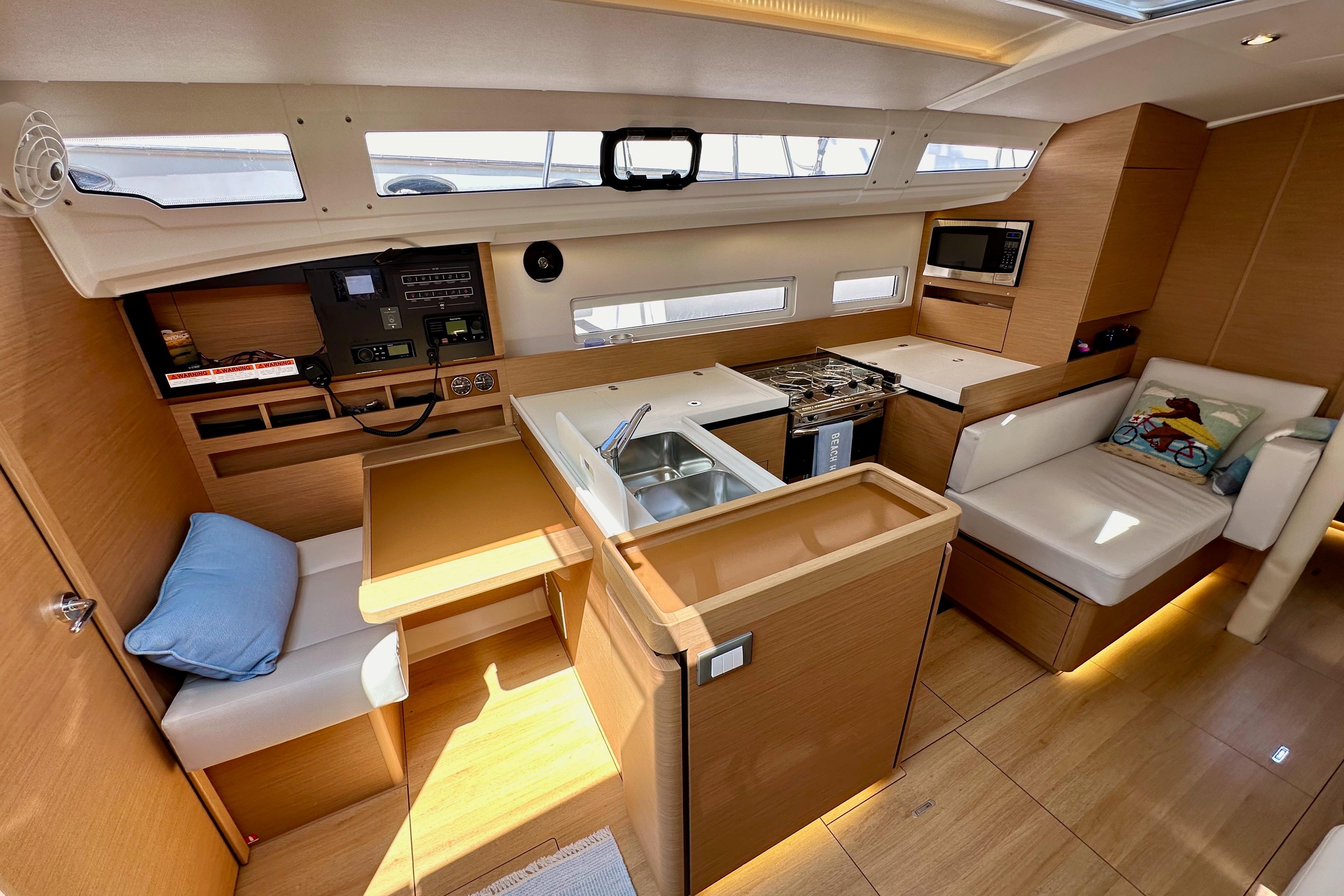 2024 Jeanneau Sun Odyssey 410 interior with modern kitchen and cozy seating area.