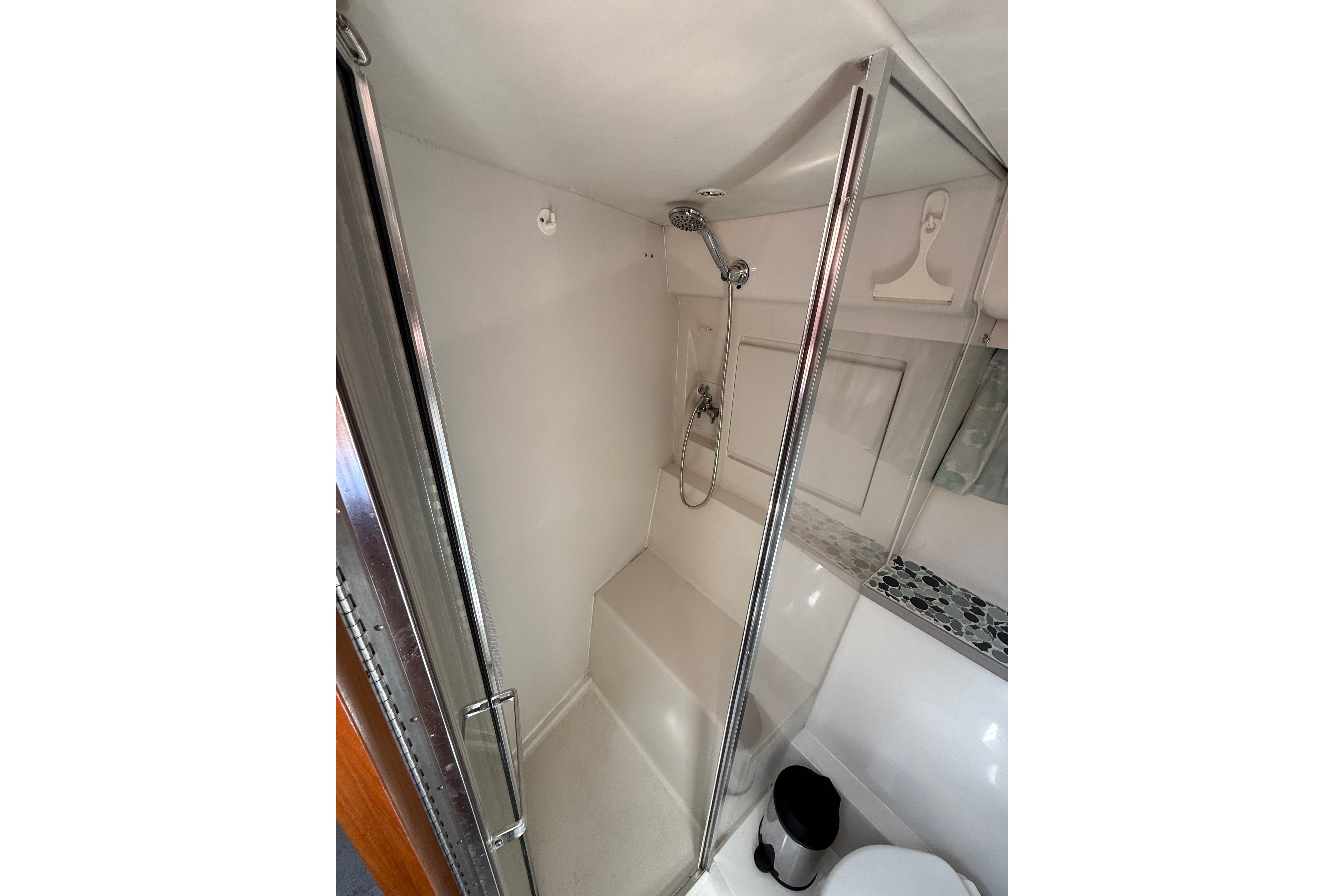 Shower area in 1995 Carver 370 Voyager yacht, featuring glass door and modern fixtures.