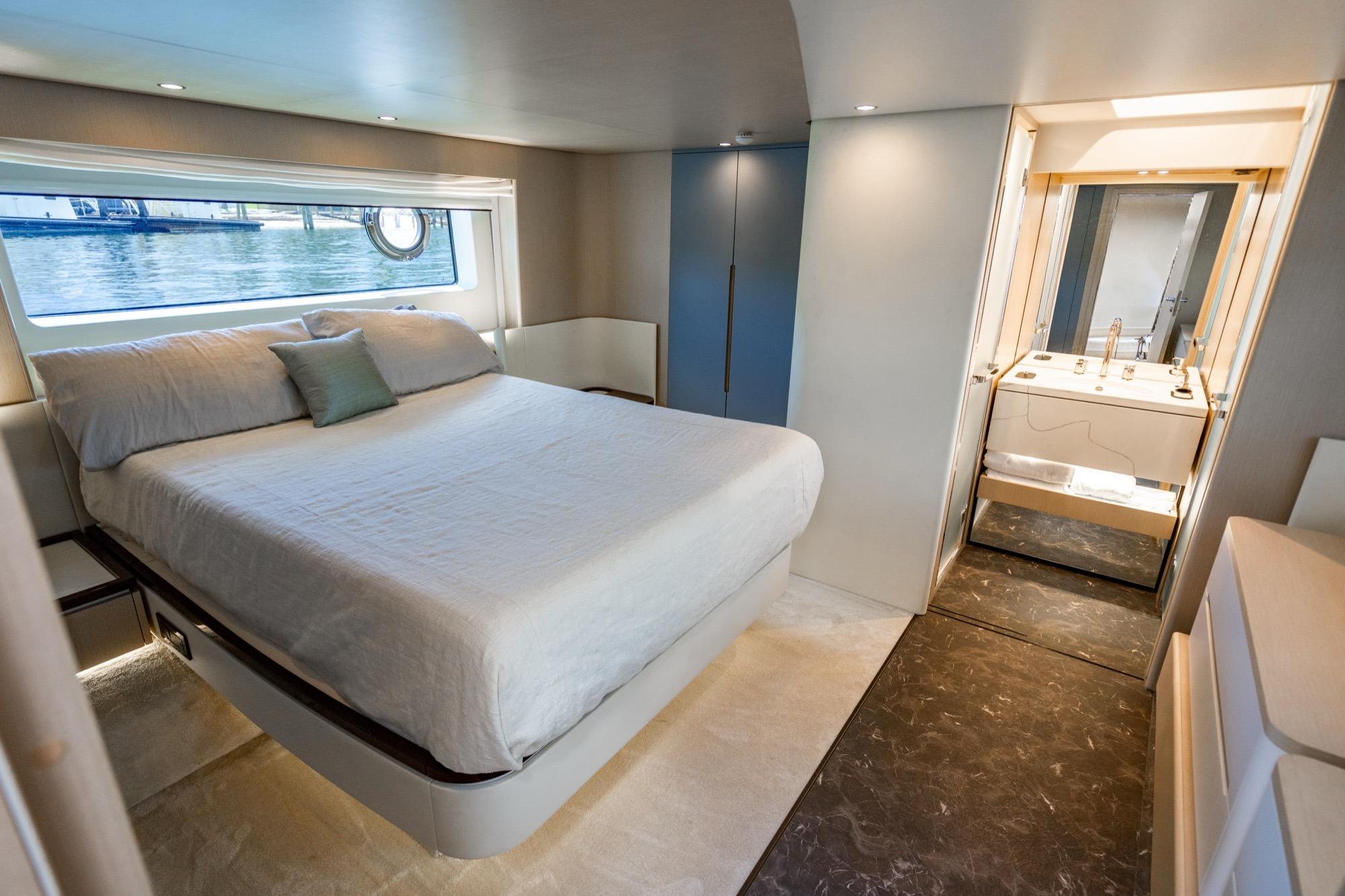 Luxurious bedroom interior of 2023 Azimut Fly 68 yacht with ensuite bathroom.