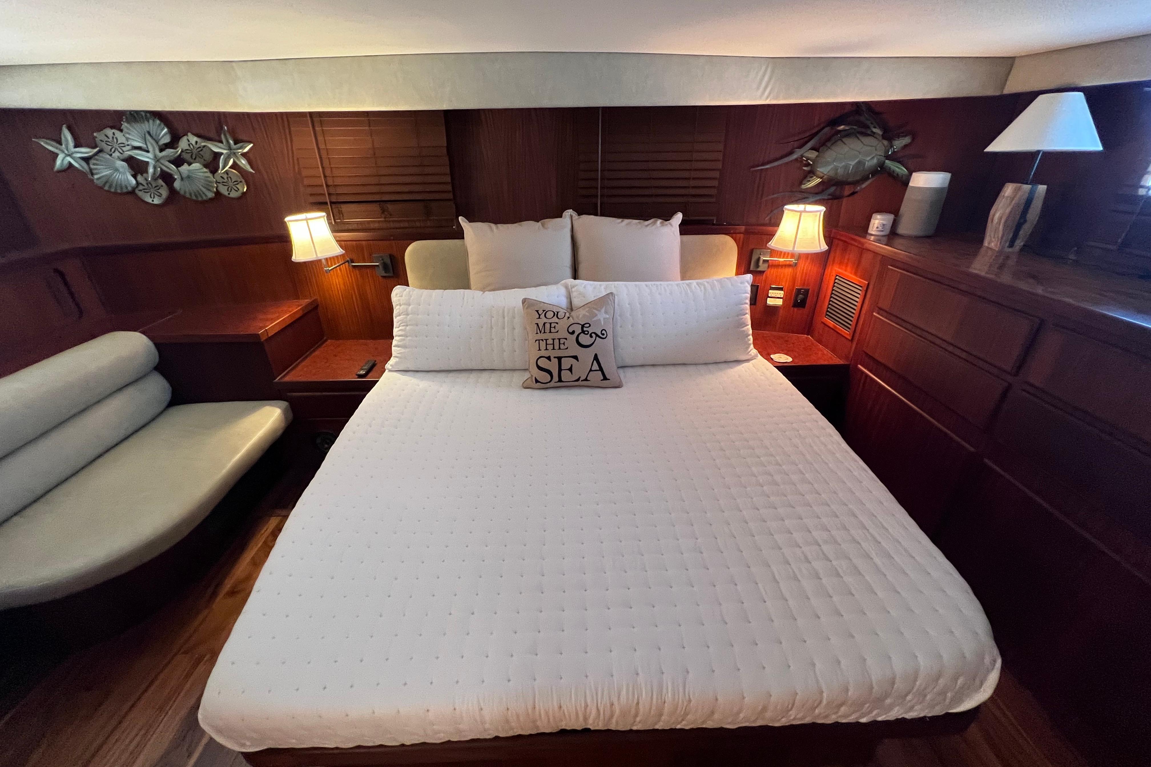 Luxurious bedroom in 1987 Hatteras 70 Cockpit Motor Yacht with elegant decor.