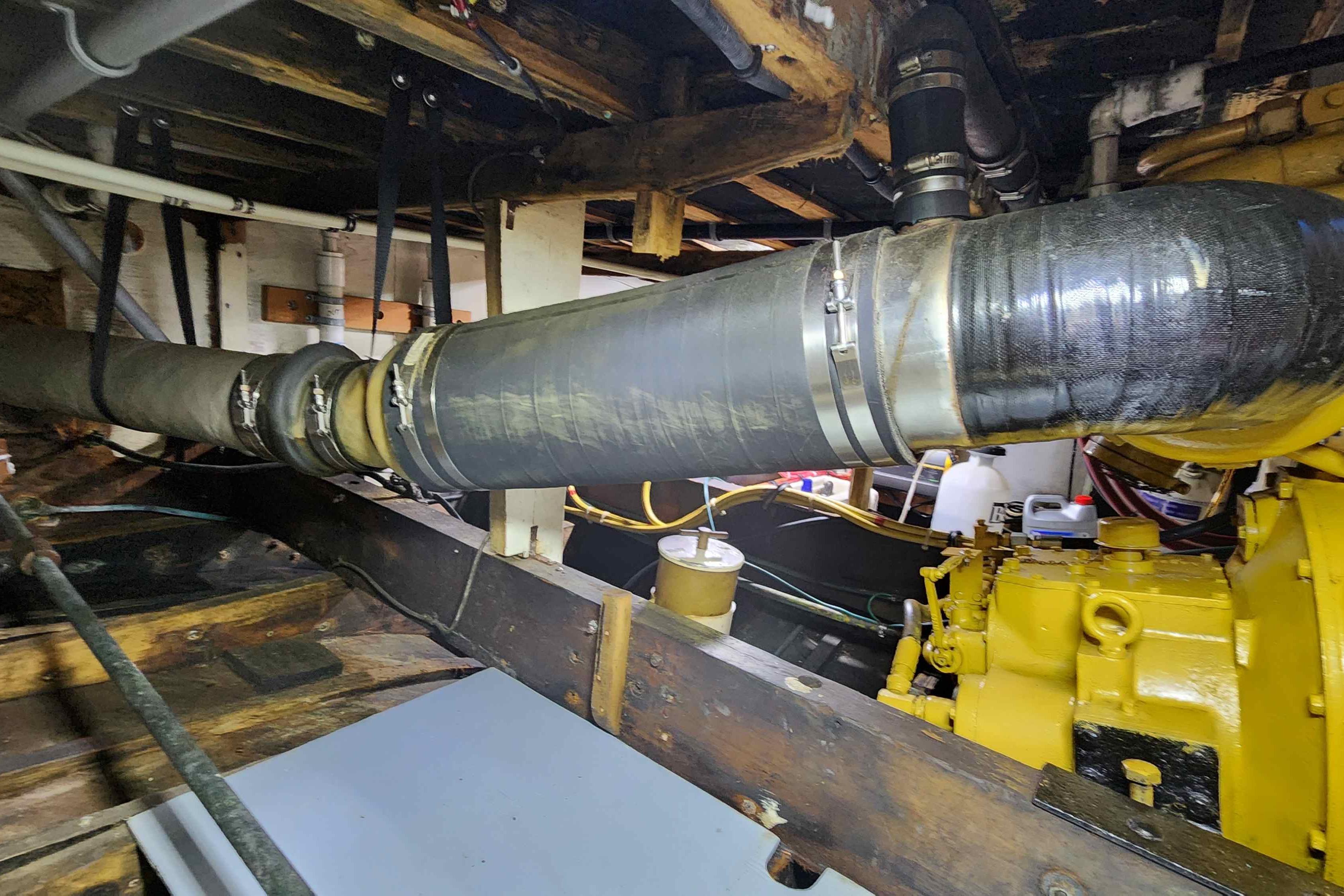 Engine room of a 1964 Grandy Tour Boat with visible exhaust system and machinery.
