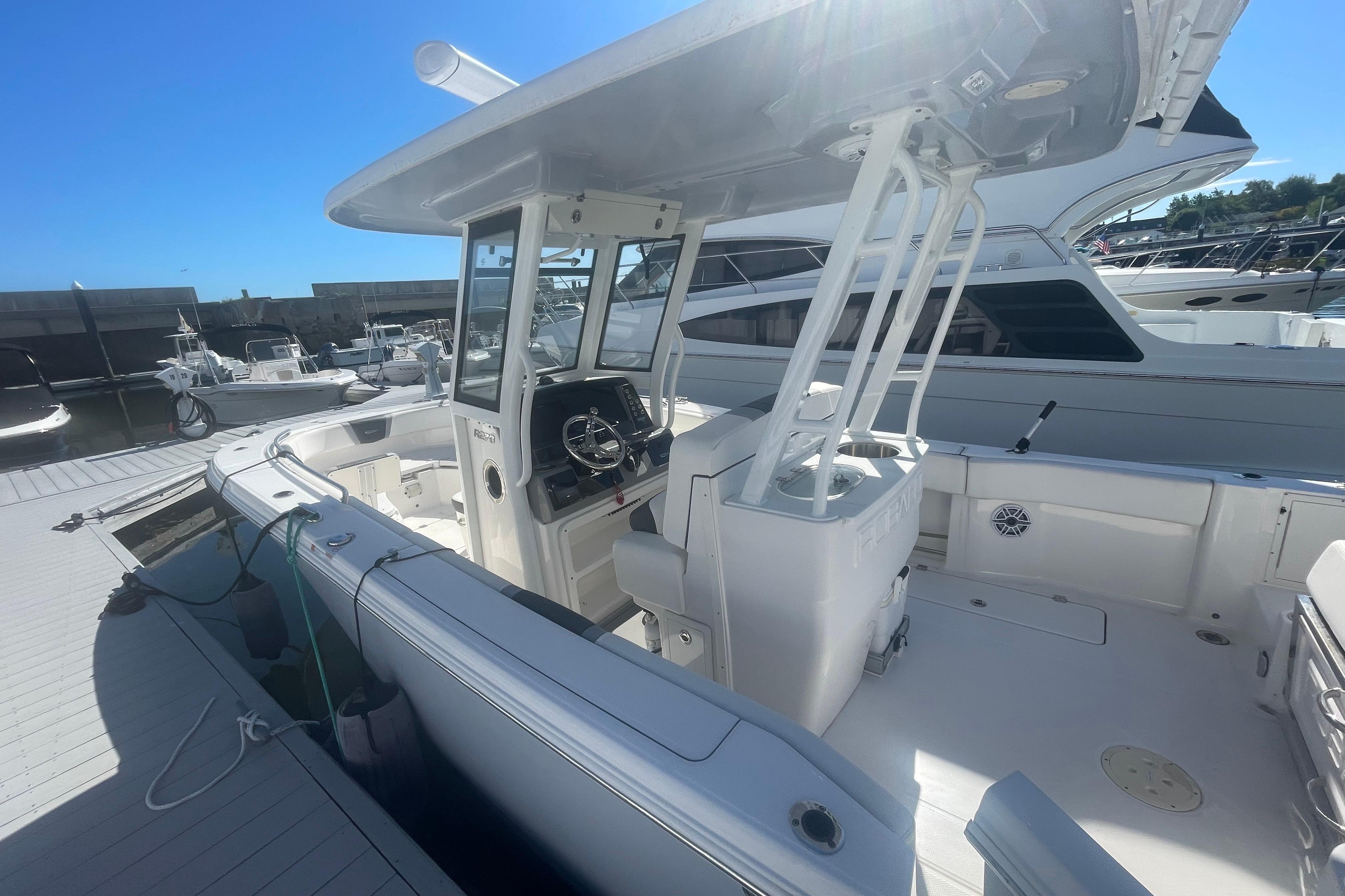 2023 Robalo R270 Center Console boat docked at marina under clear blue sky.