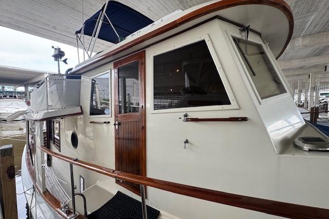 1986 Krogen 42 Classic yacht with wooden accents docked under a canopy.