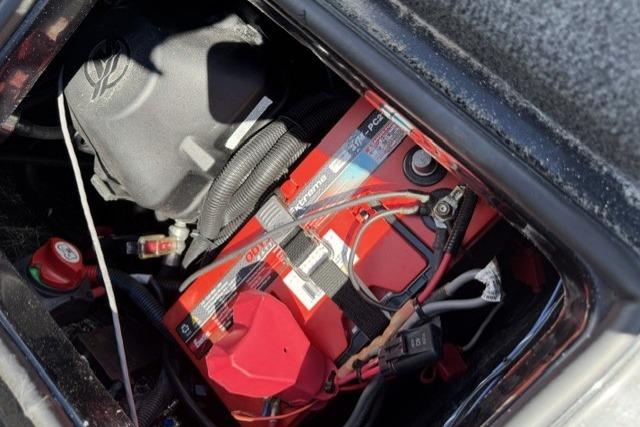 Battery compartment of a 2016 Triton 216 Fishunter boat, featuring a red marine battery.