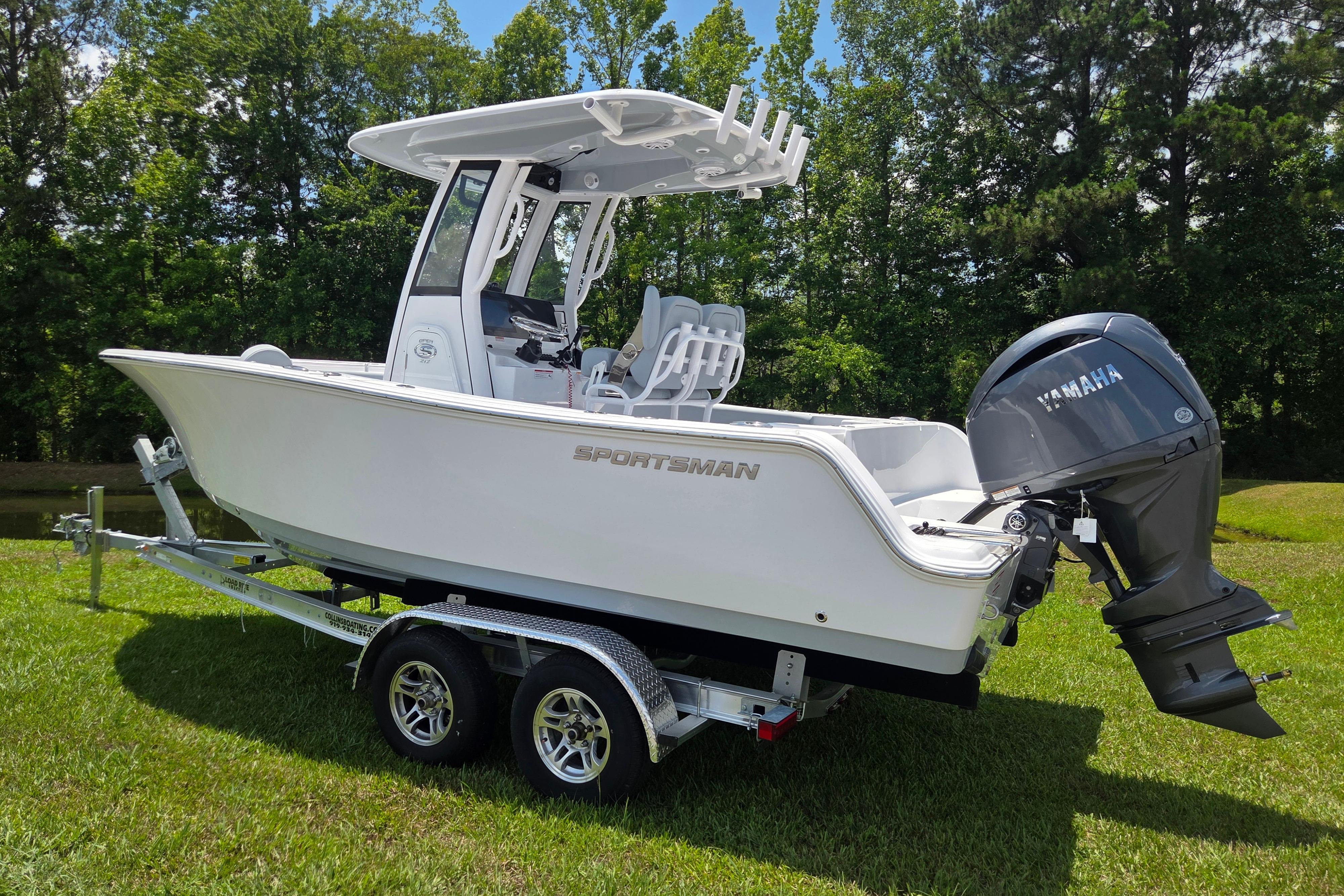 2026 Sportsman Open 212 Center Console boat on trailer, parked on grass.