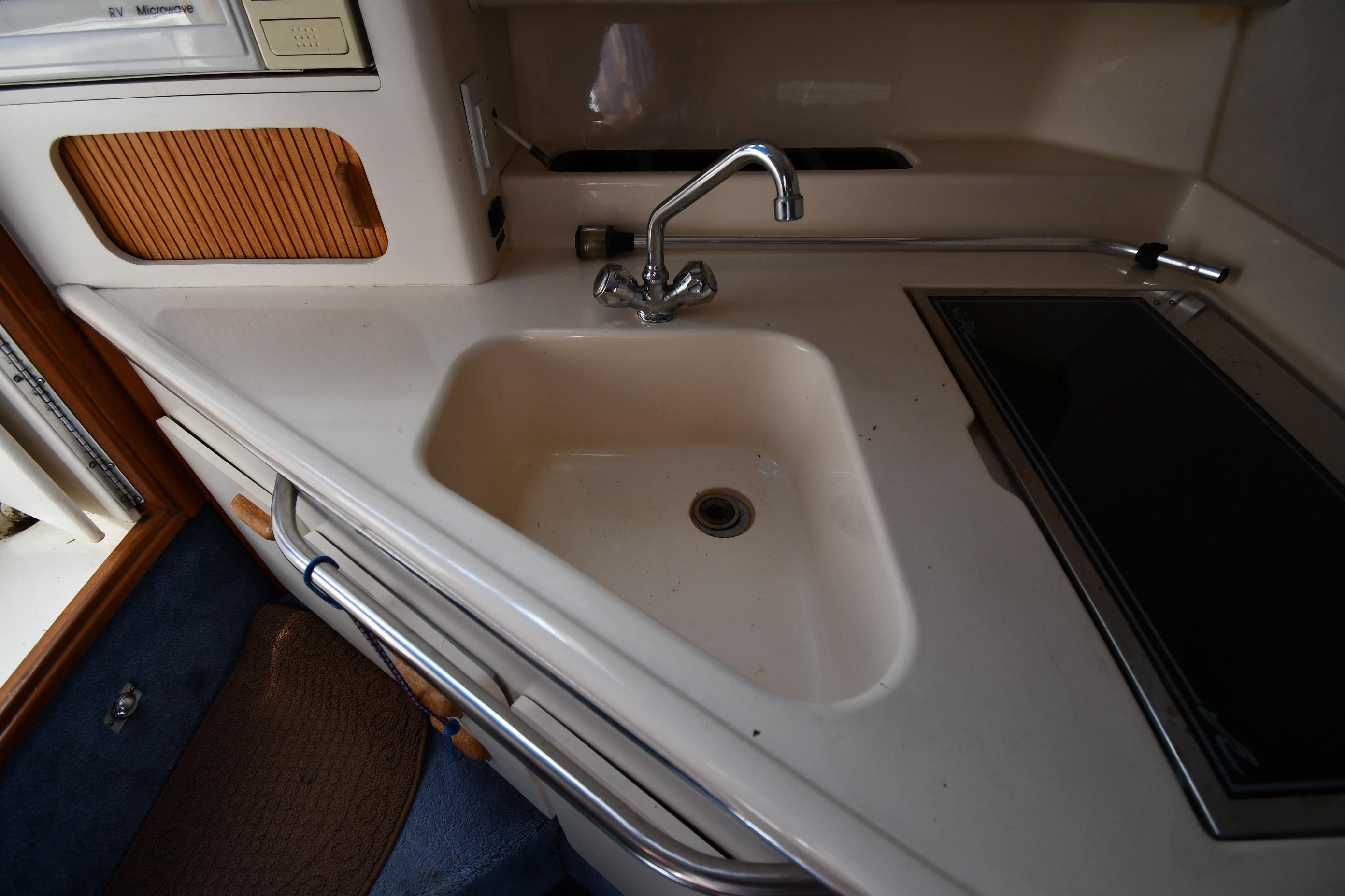 1993 Sea Ray 300 Sundancer kitchen area with sink and stove.