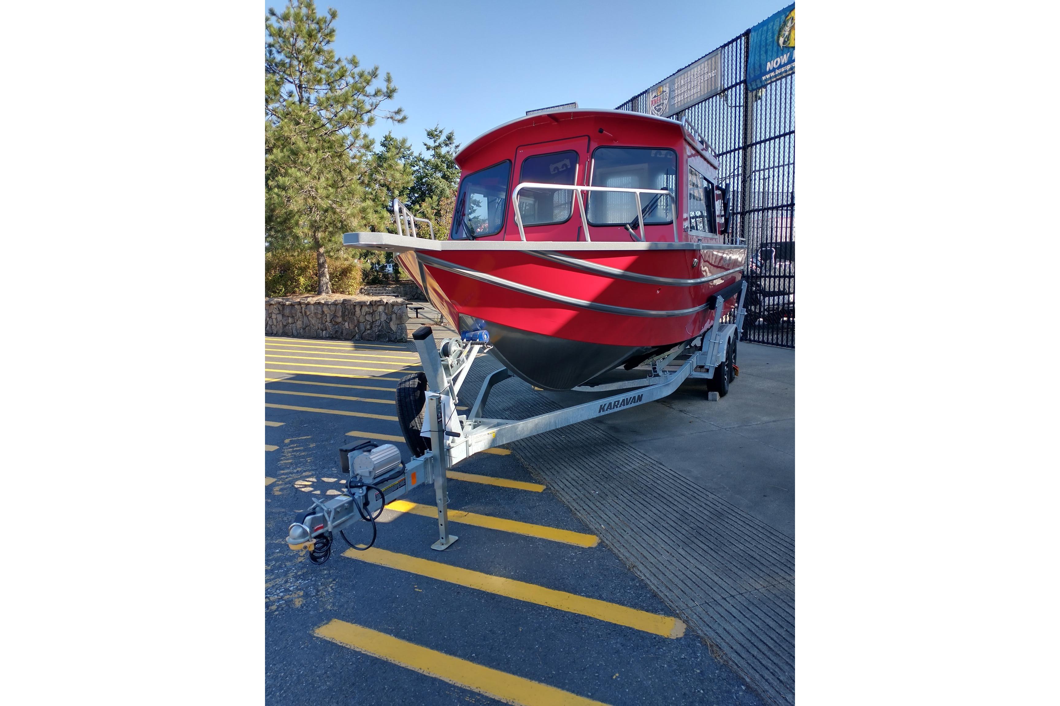 Red 2024 Spartan 220 Maximus Pro boat on trailer in outdoor setting.
