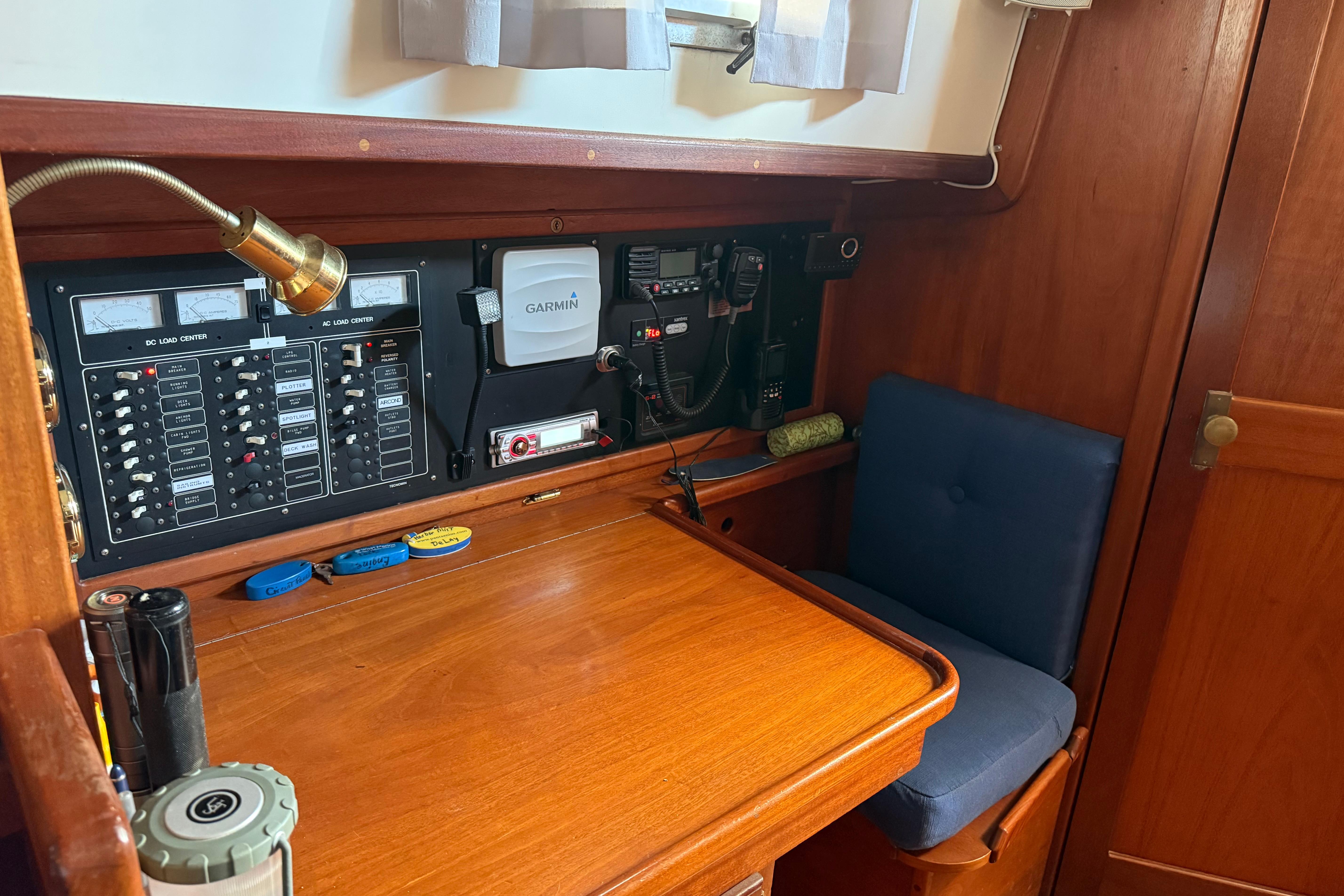 Navigation station of a 1990 Gozzard 31 sailboat with control panels and seating.