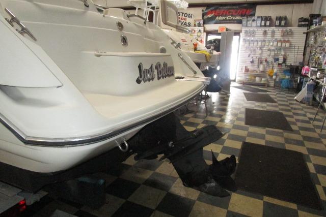 2004 Stingray 240 LR boat in showroom, checkered floor, rear view.