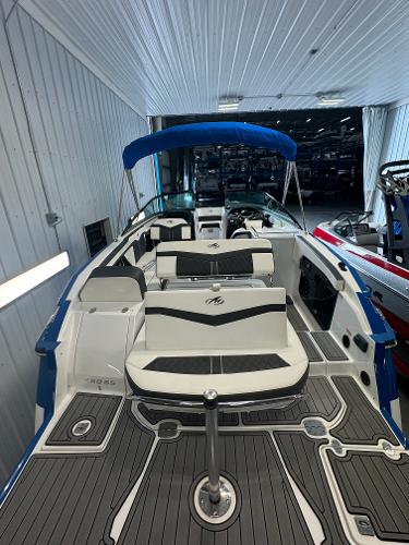 2018 Monterey 258 Super Sport boat with sleek interior and blue canopy in showroom.