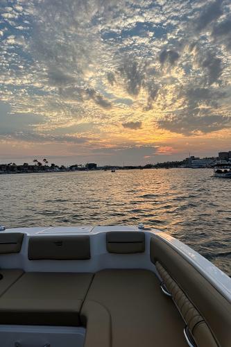2024 Bayliner DX 2250 boat at sunset on a tranquil lake.