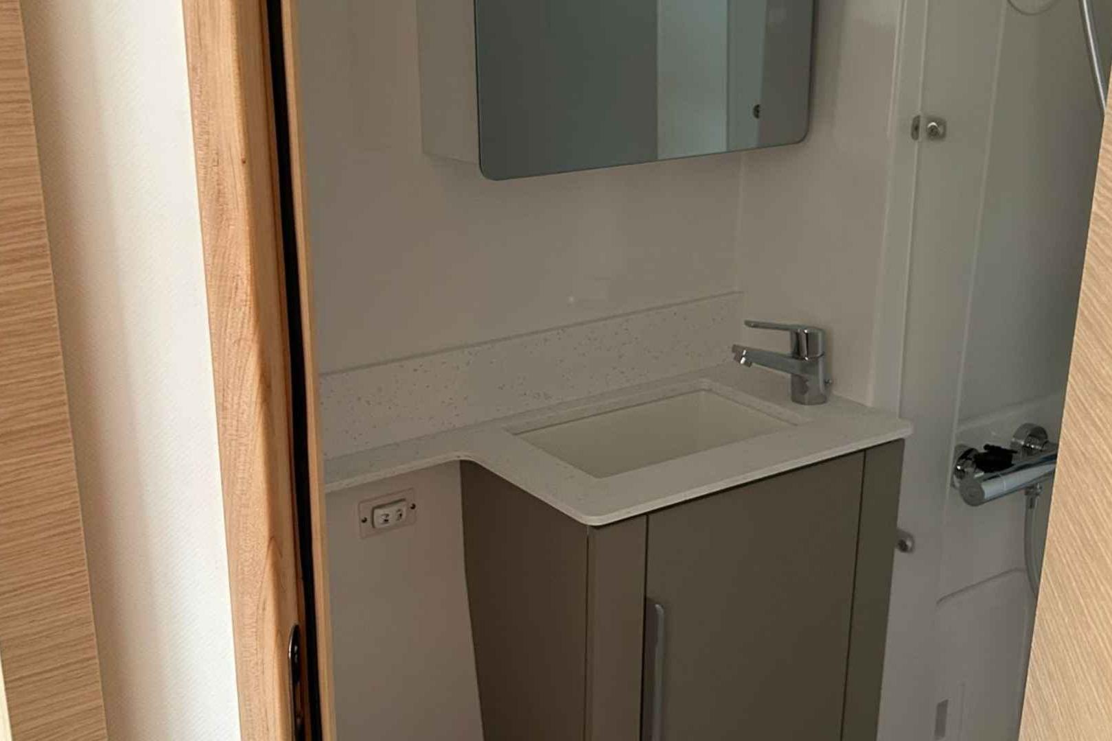 Modern bathroom interior on 2026 Fountaine Pajot 44 yacht, featuring sleek sink and cabinetry.