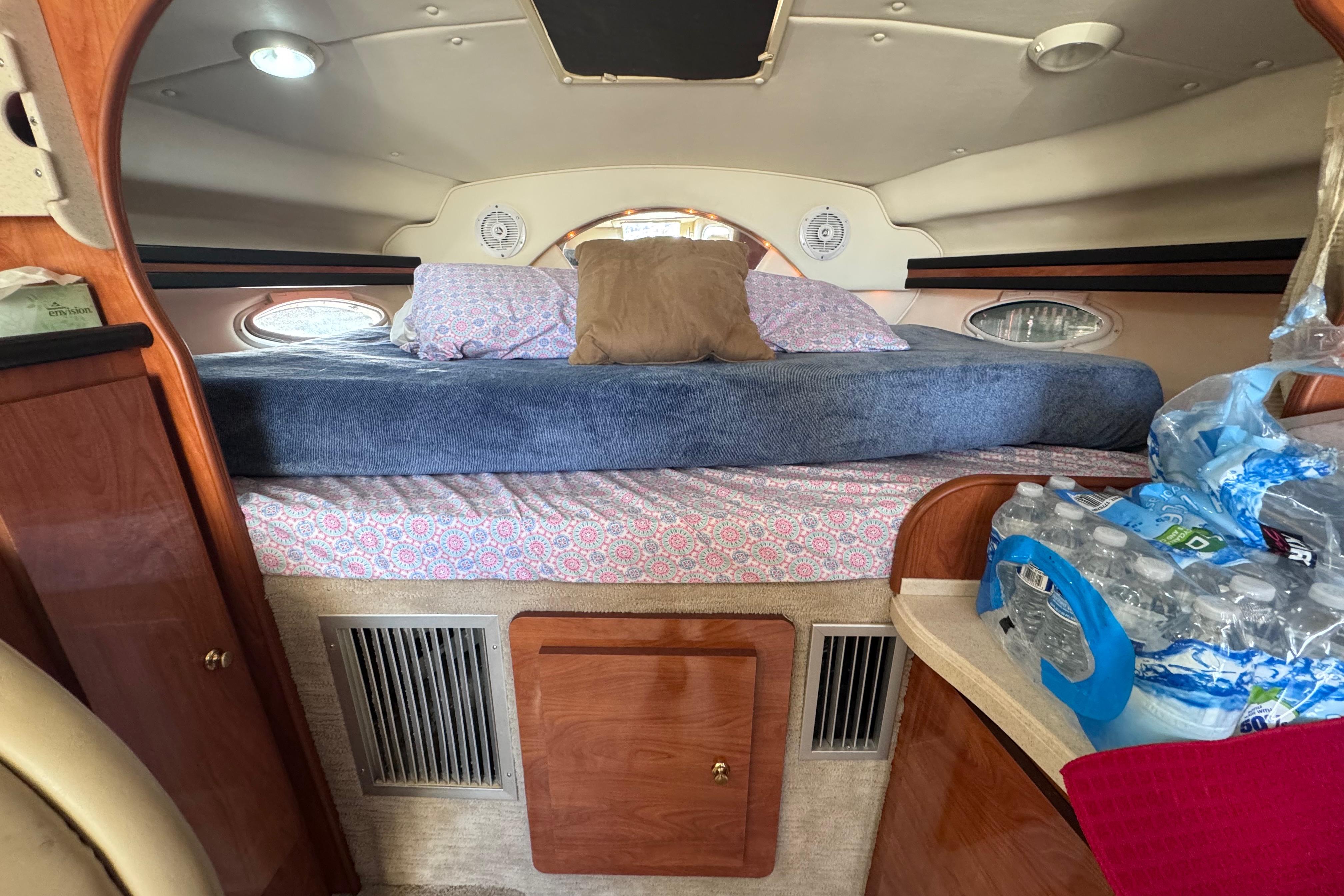 Interior cabin of 2003 Rinker Fiesta Vee 312 with bed and storage.