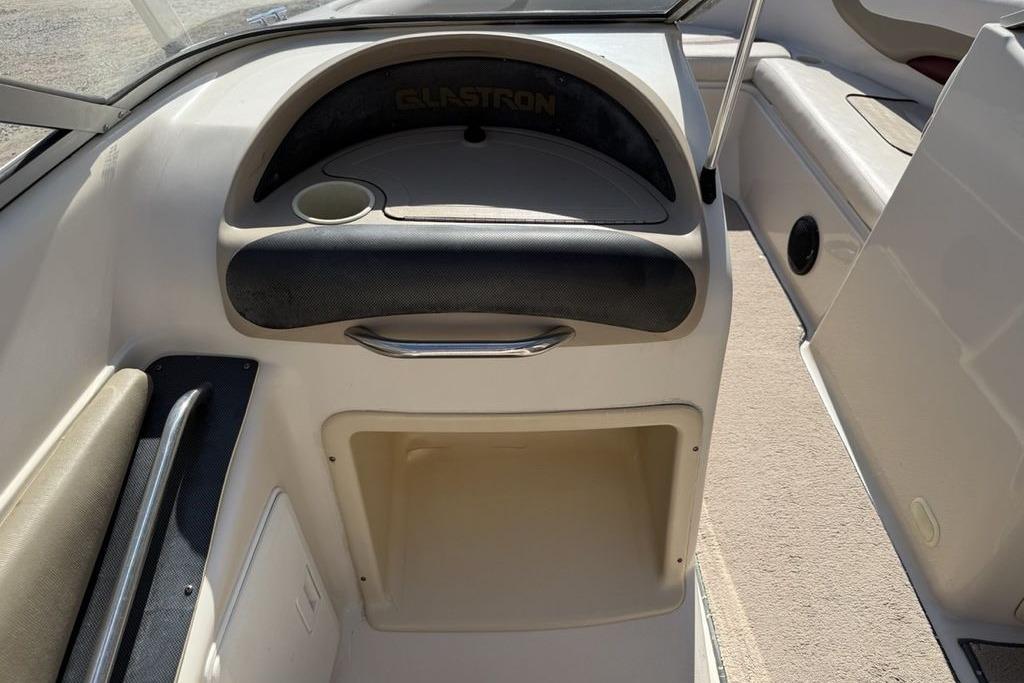 1999 Glastron GT 225 boat interior with storage compartment and cup holder.