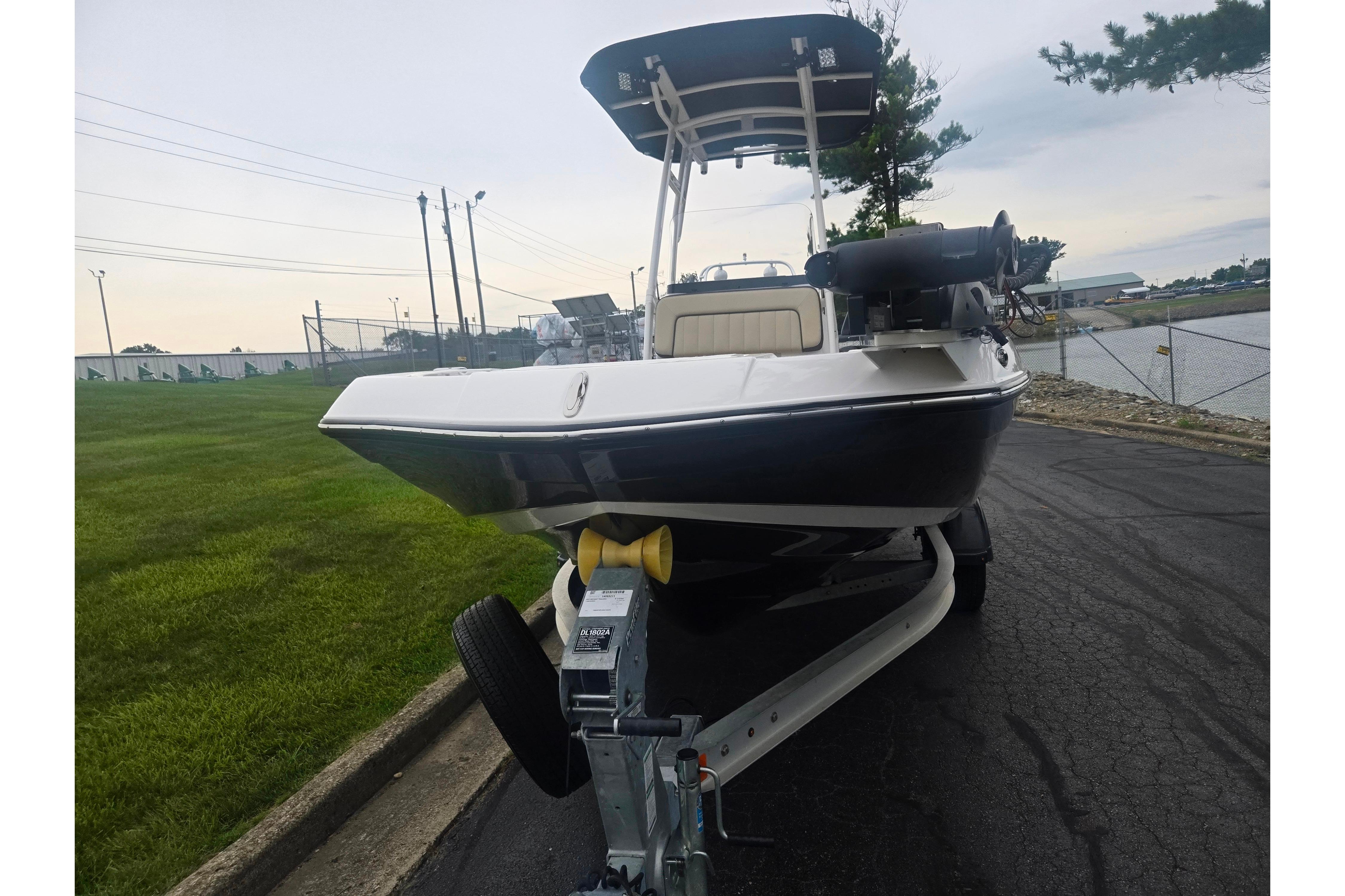 2022 Yamaha Boats 195 FSH Sport on trailer, parked near water and grassy area.