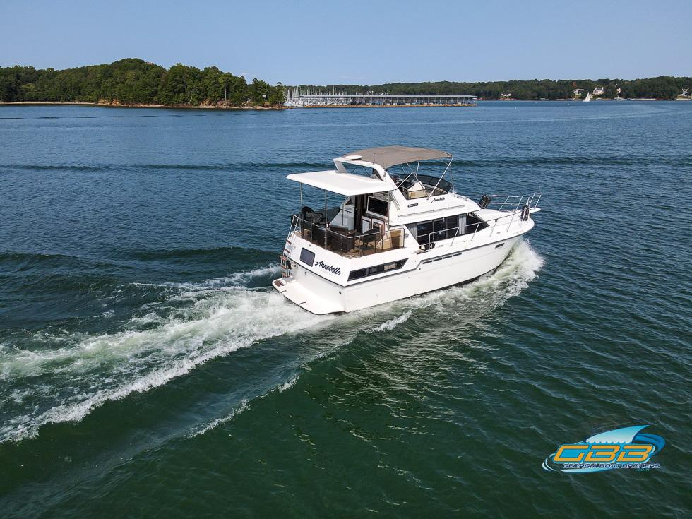 1989 Carver 3807 Aft Cabin cruising on a serene lake.