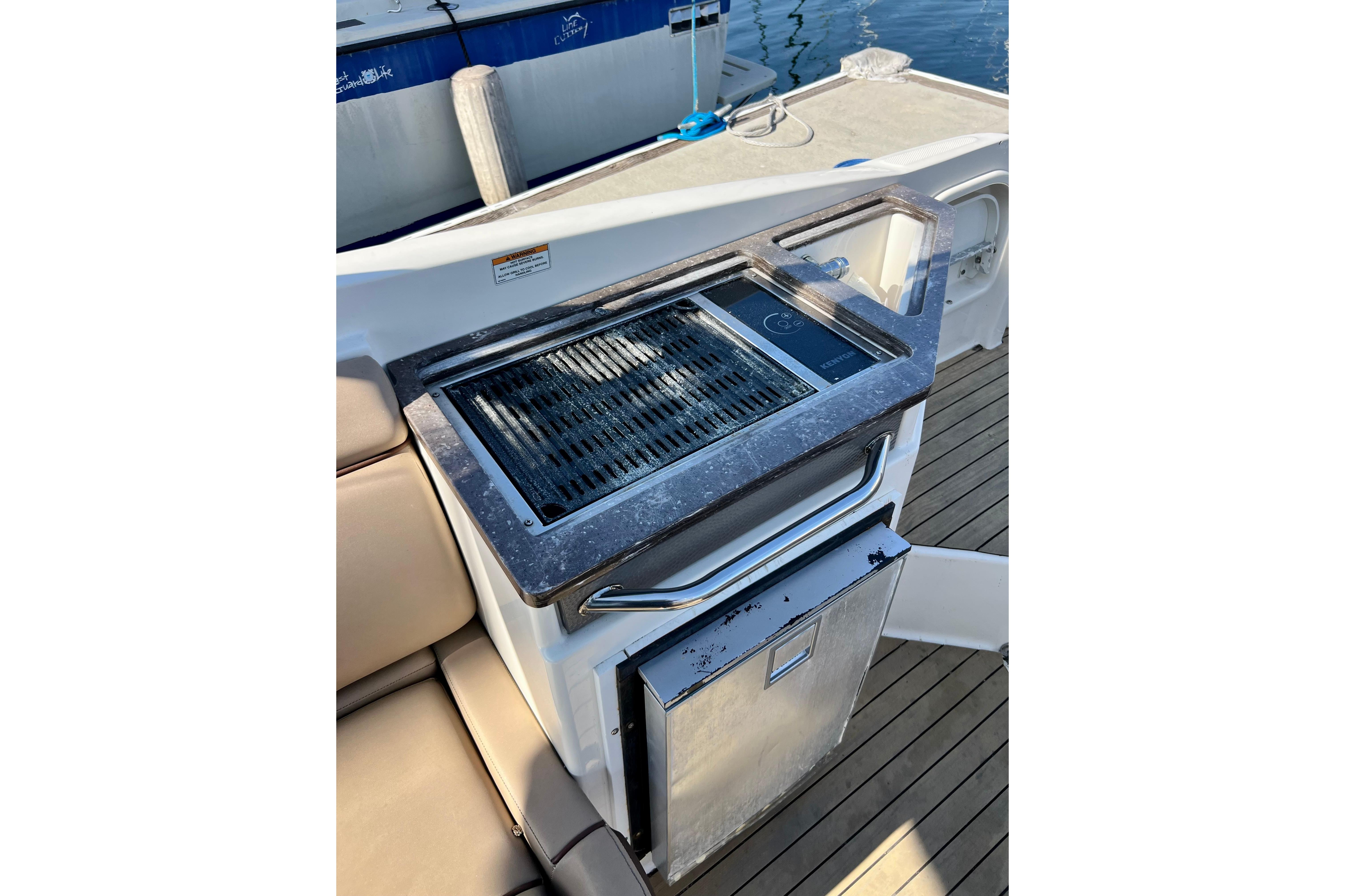 Outdoor grill and mini-fridge on 2016 Sea Ray 290 Sundeck Outboard boat deck.