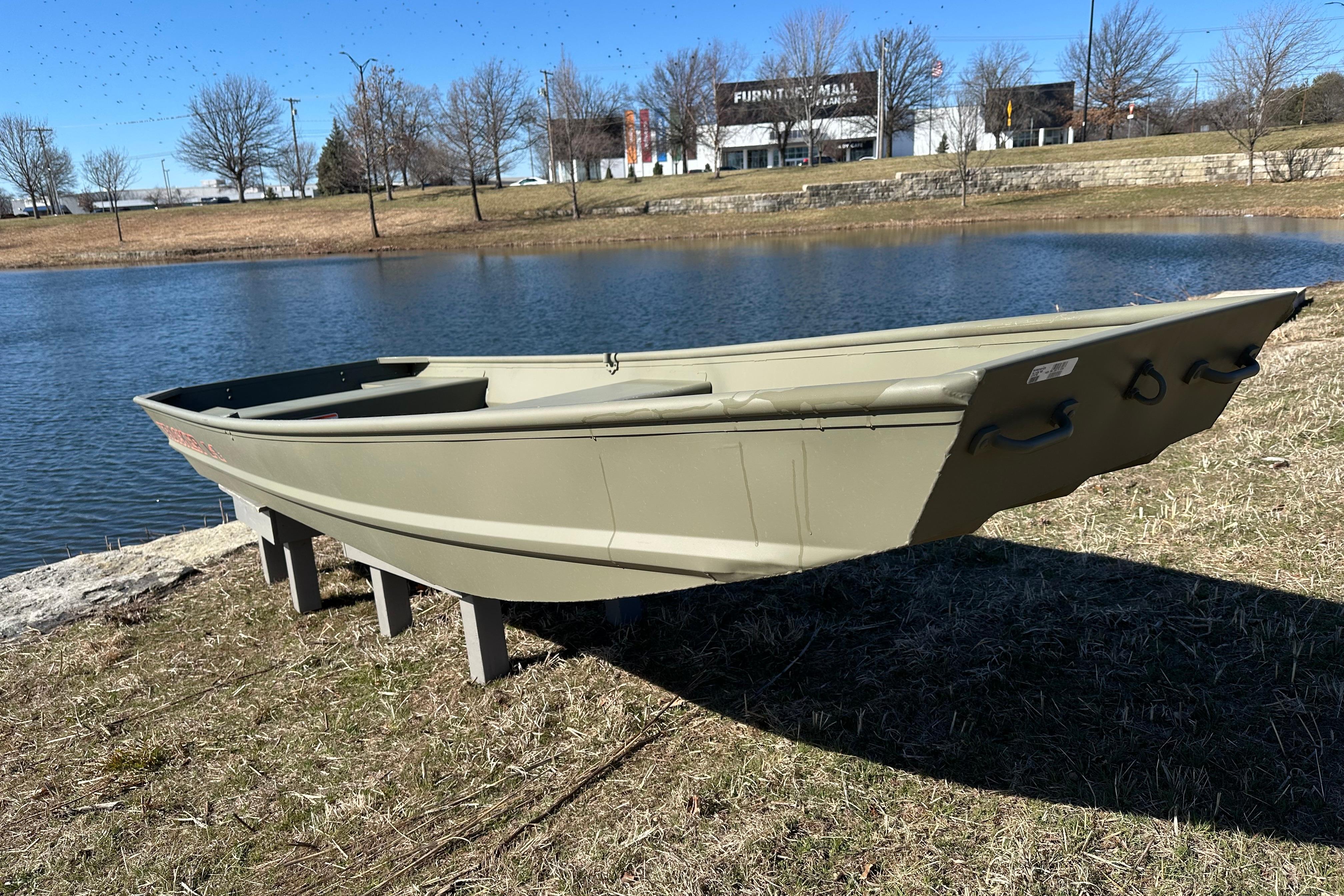 2026 Tracker Grizzly 14 Jon boat displayed near a serene lake.