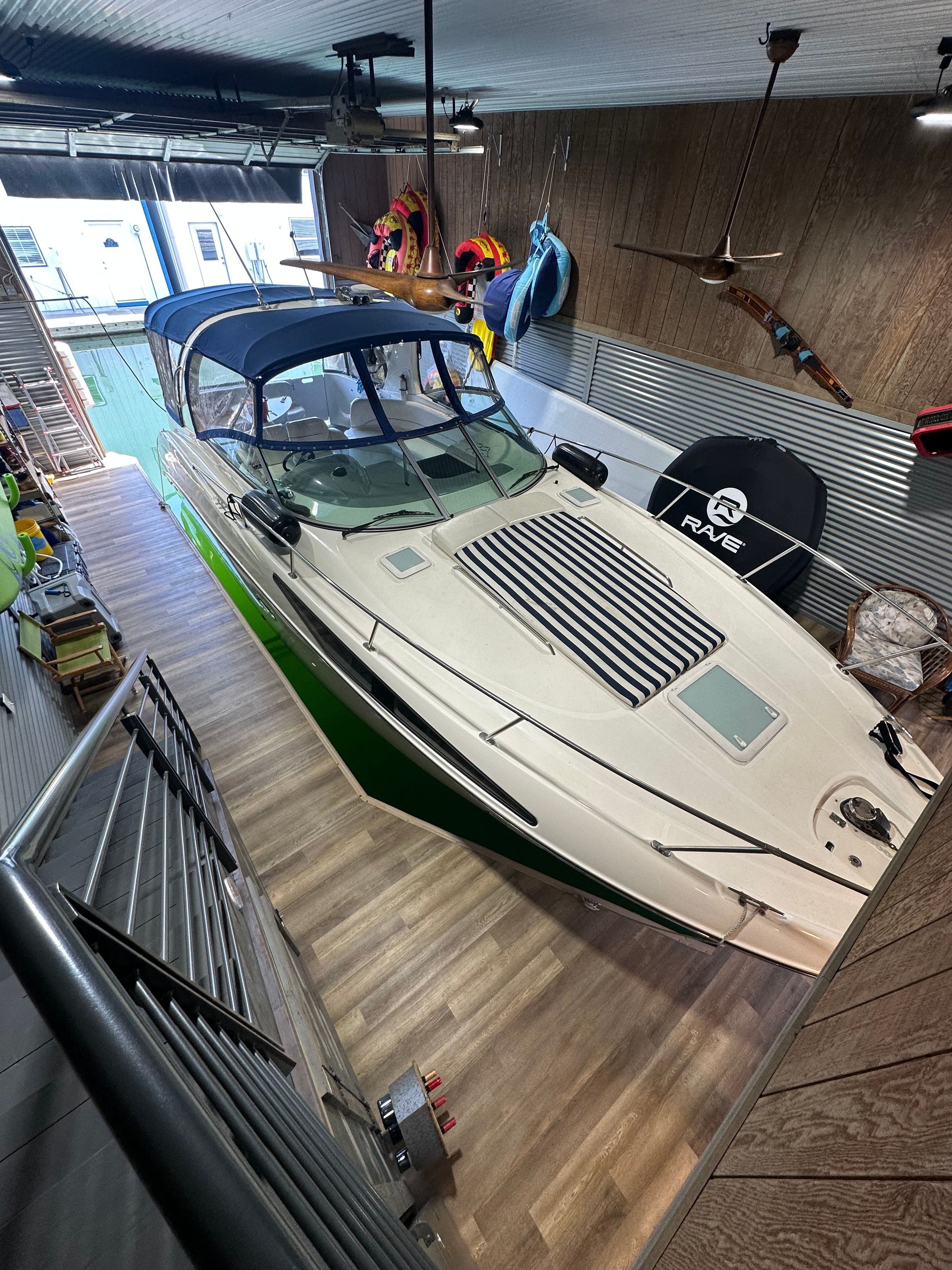 2008 Bayliner 340 boat in a garage with wooden walls.
