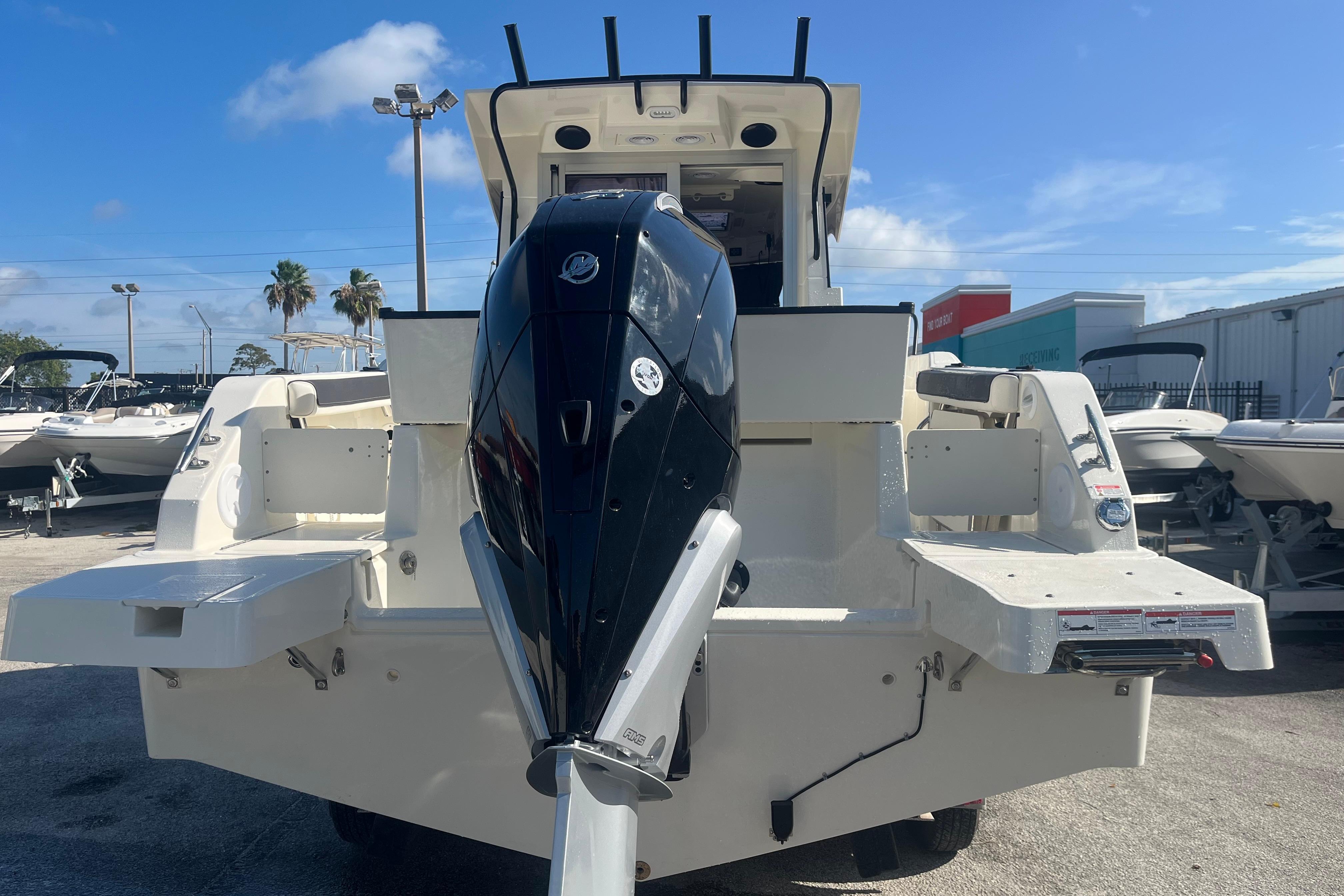 2025 Bayliner Trophy T25 Pilothouse boat with powerful outboard motor, docked outdoors.