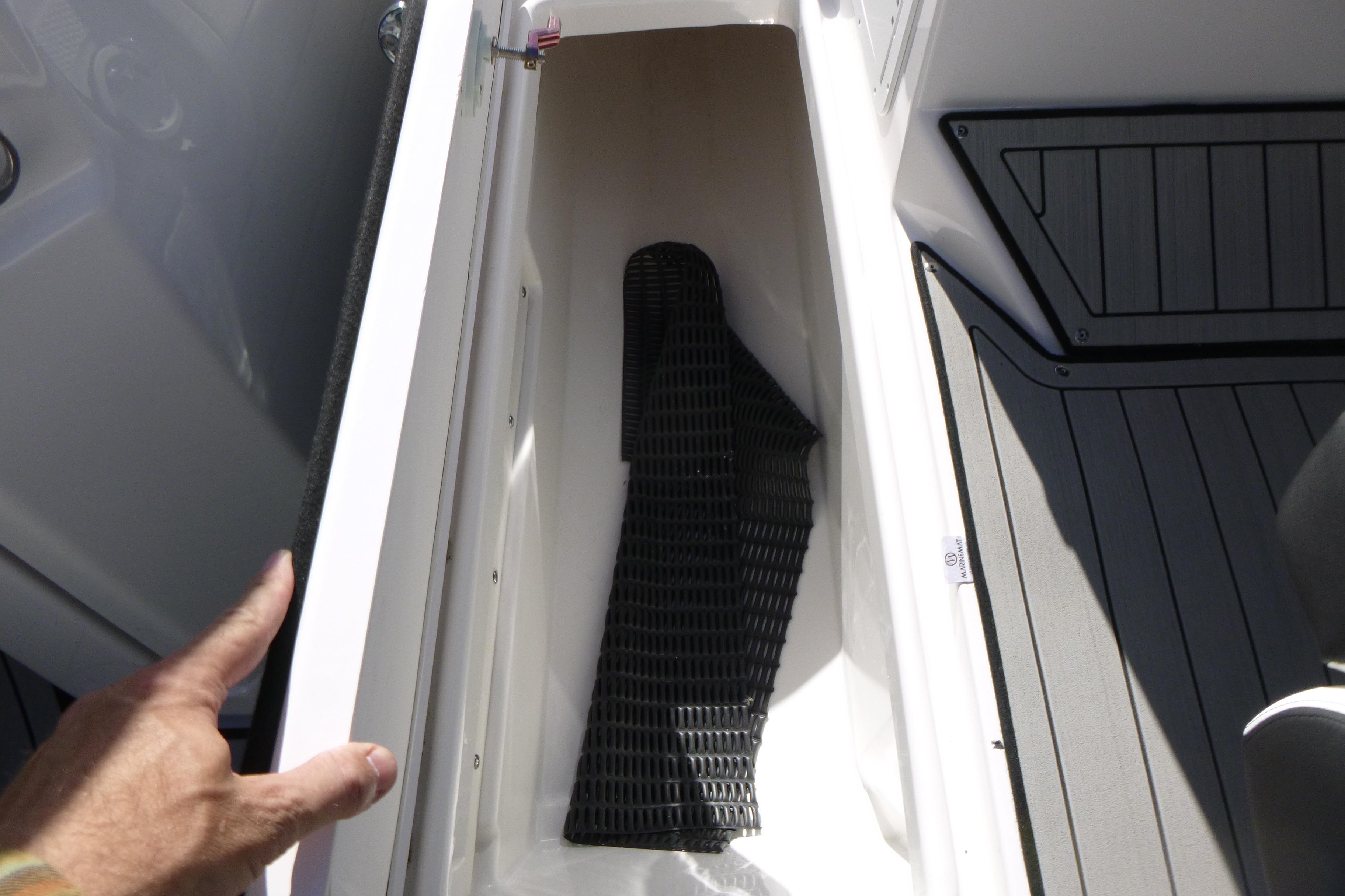 Storage compartment in 2026 Yamaha Boats 252SD, featuring a black mat and sleek design.