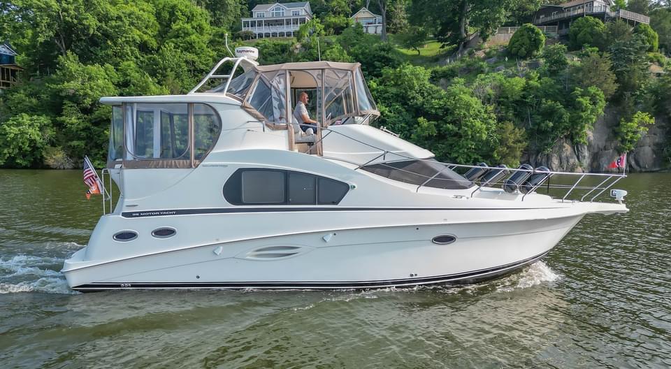 2007 Silverton 35 Motor Yacht cruising on a scenic river with lush greenery.