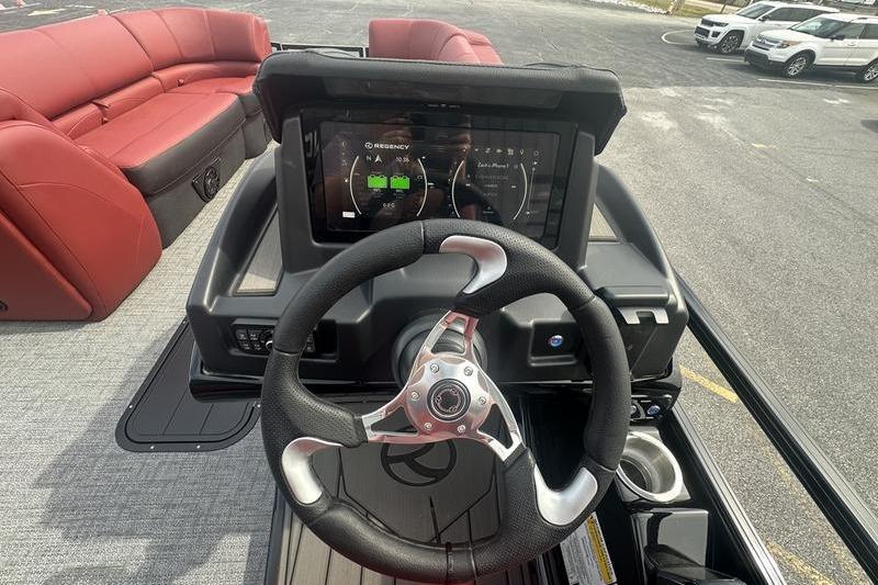 Steering console of 2026 Regency 230 DL boat with digital display and red seating.