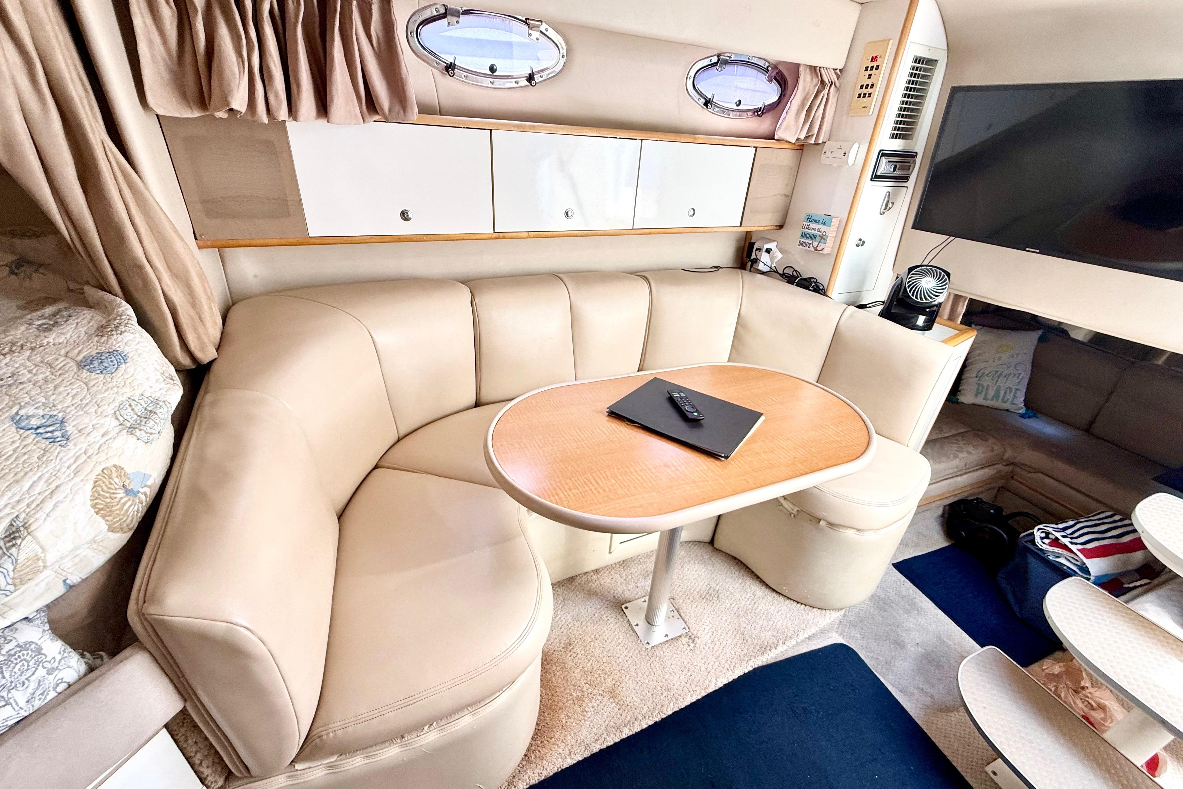 Interior of 1999 Chaparral Signature 300 yacht with beige seating and wooden table.