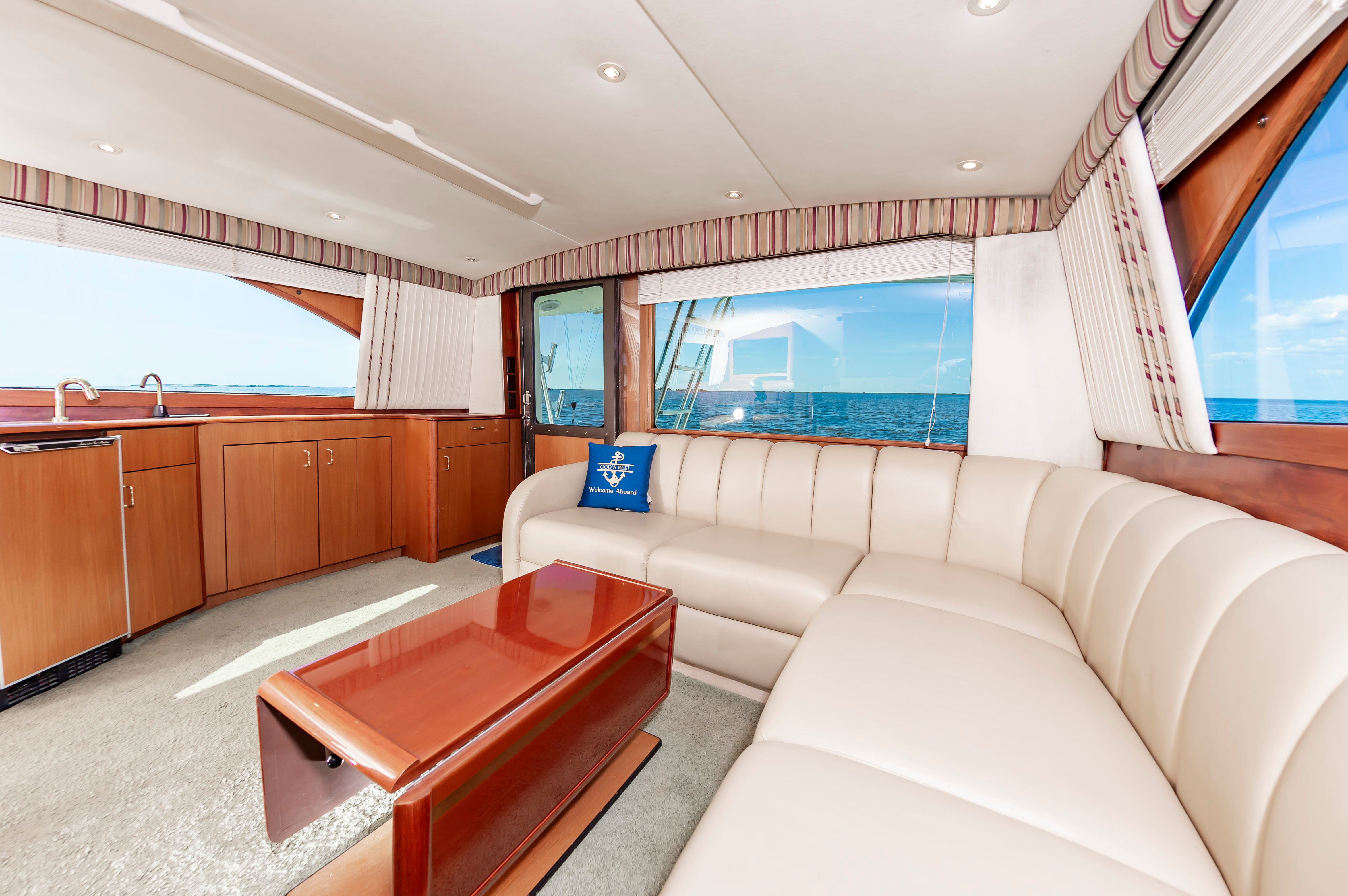 Interior of 2000 Ocean 48 SuperSport yacht with luxurious sofa and ocean view.