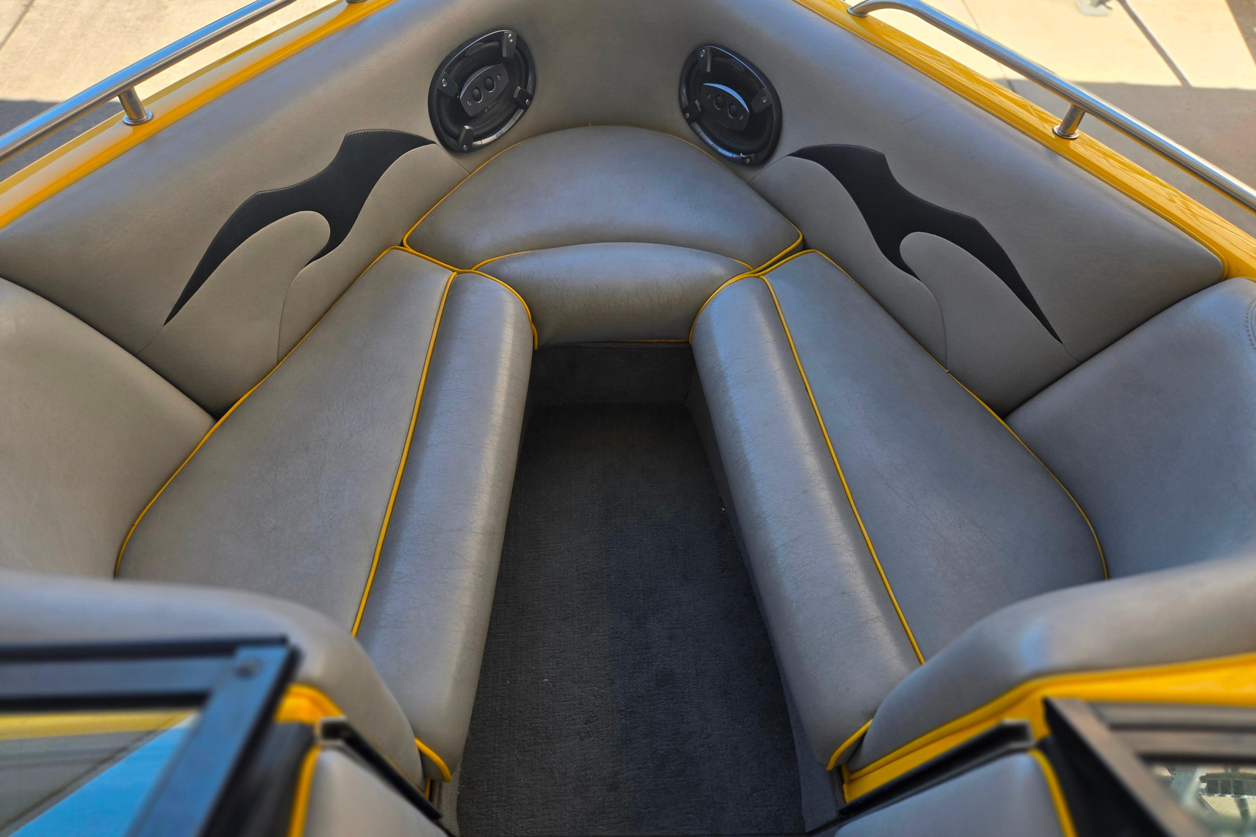 Interior of 2007 Calabria CAL AIR PRO V boat with gray seating and yellow accents.