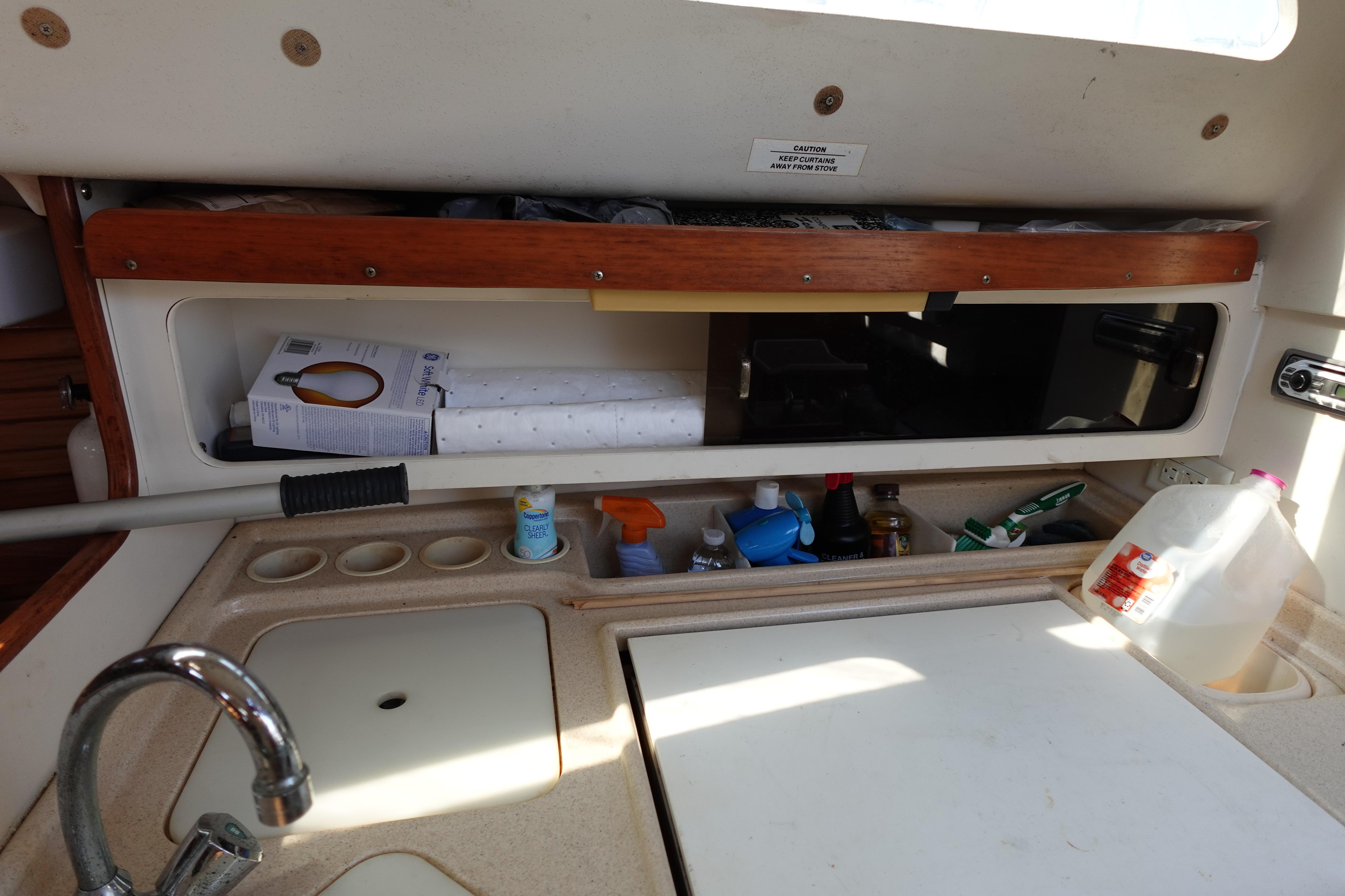 Interior of a 1997 Catalina 28 sailboat kitchen with sink and storage.
