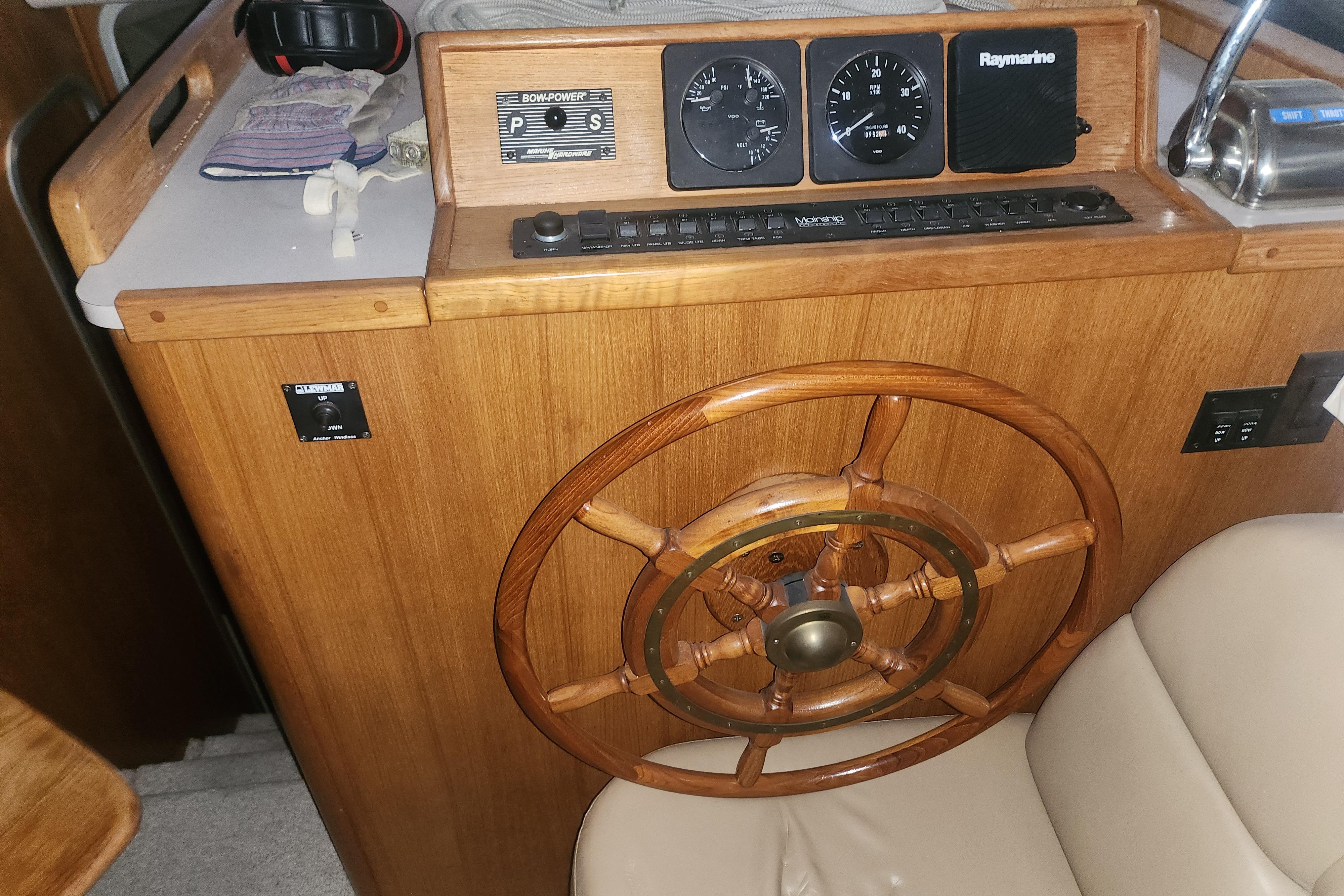 1997 Mainship 350 Trawler helm with wooden wheel and navigation instruments.